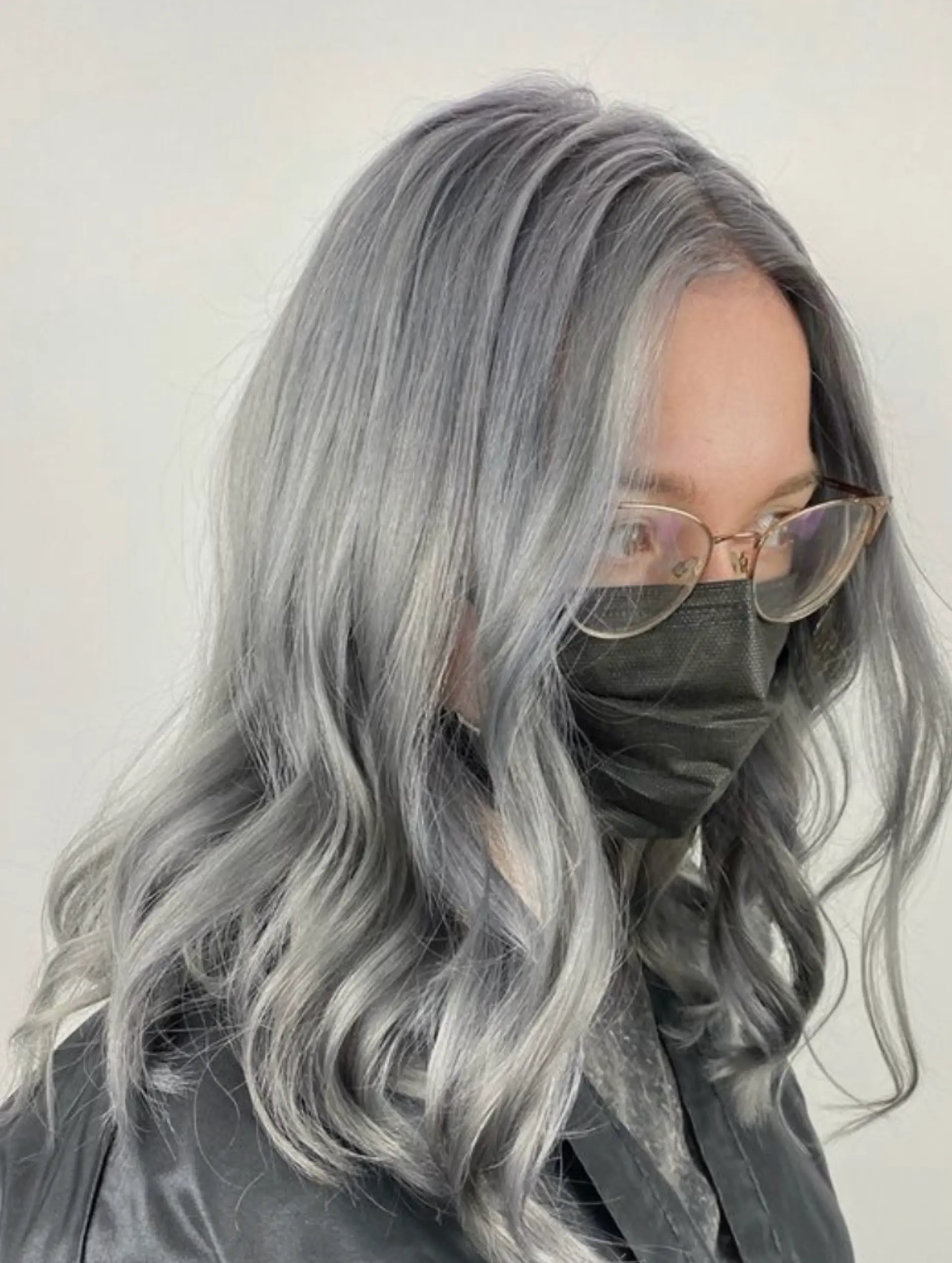Medium-length, silver-colored hair with natural waves and a glossy finish, creating an elegant and refined look. 1