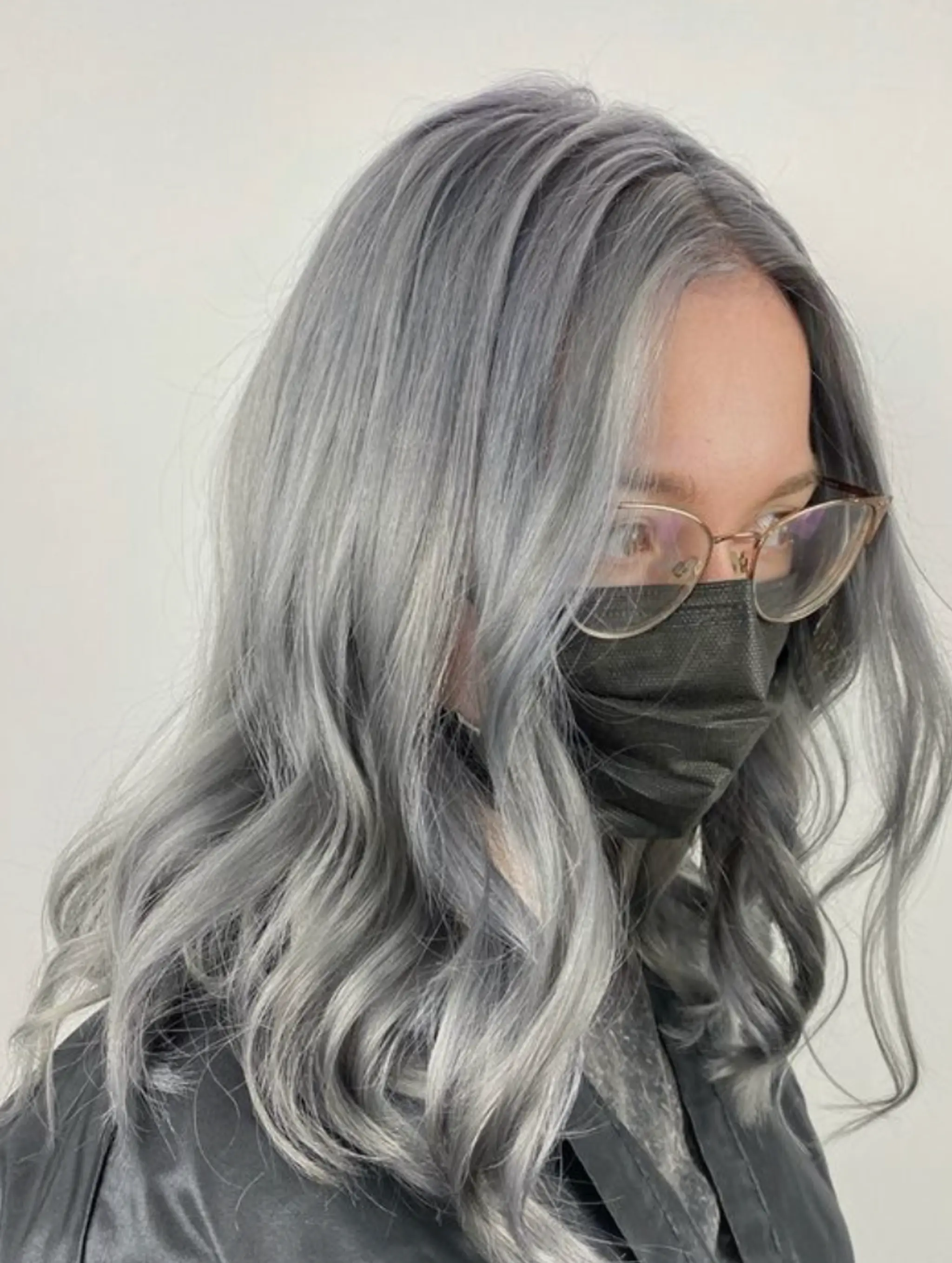 Medium-length, silver-colored hair with natural waves and a glossy finish, creating an elegant and refined look.
