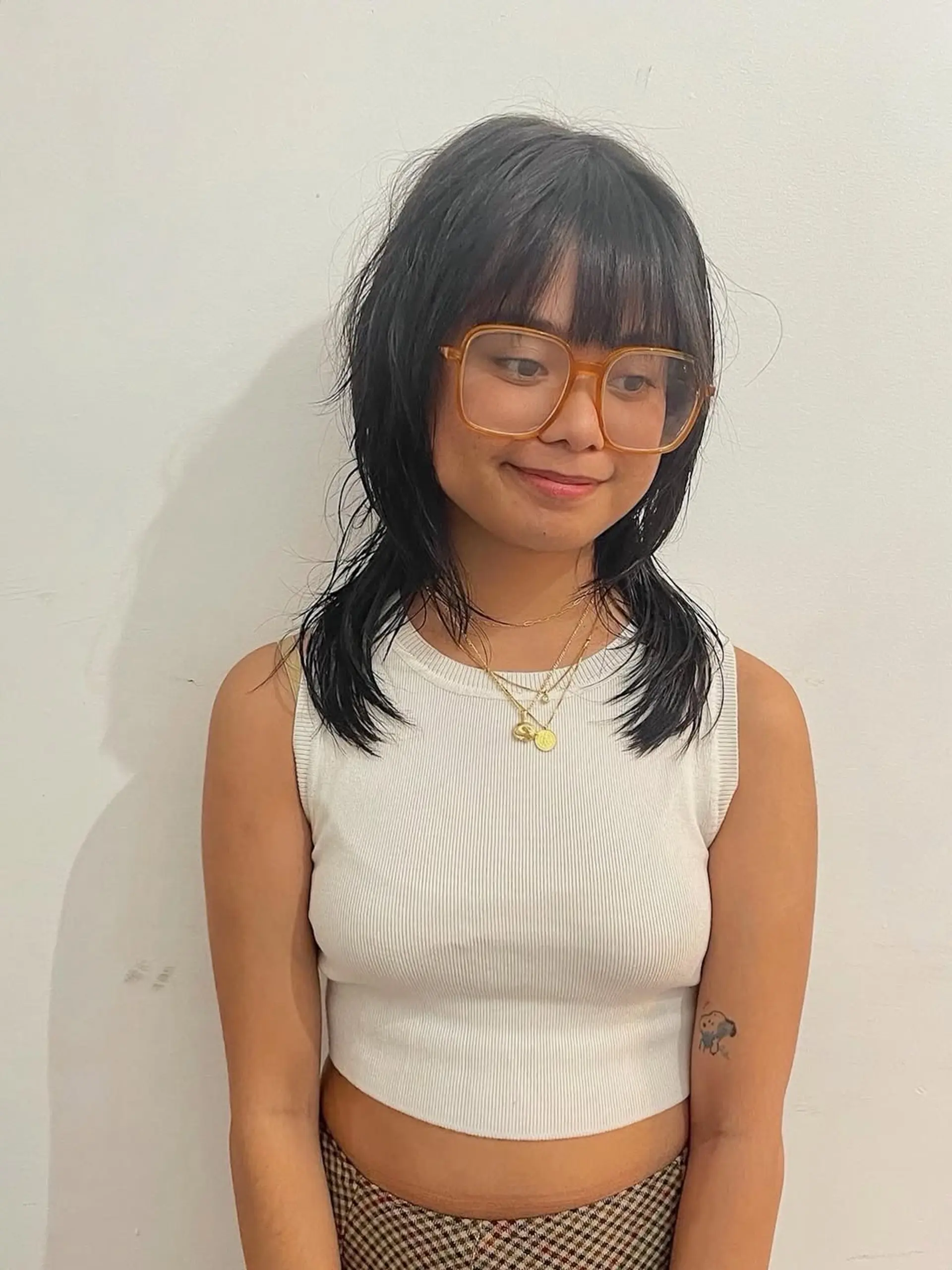 A modern shag haircut with textured, choppy layers and blunt, full bangs that frame the face, giving an edgy and trendy vibe. 1