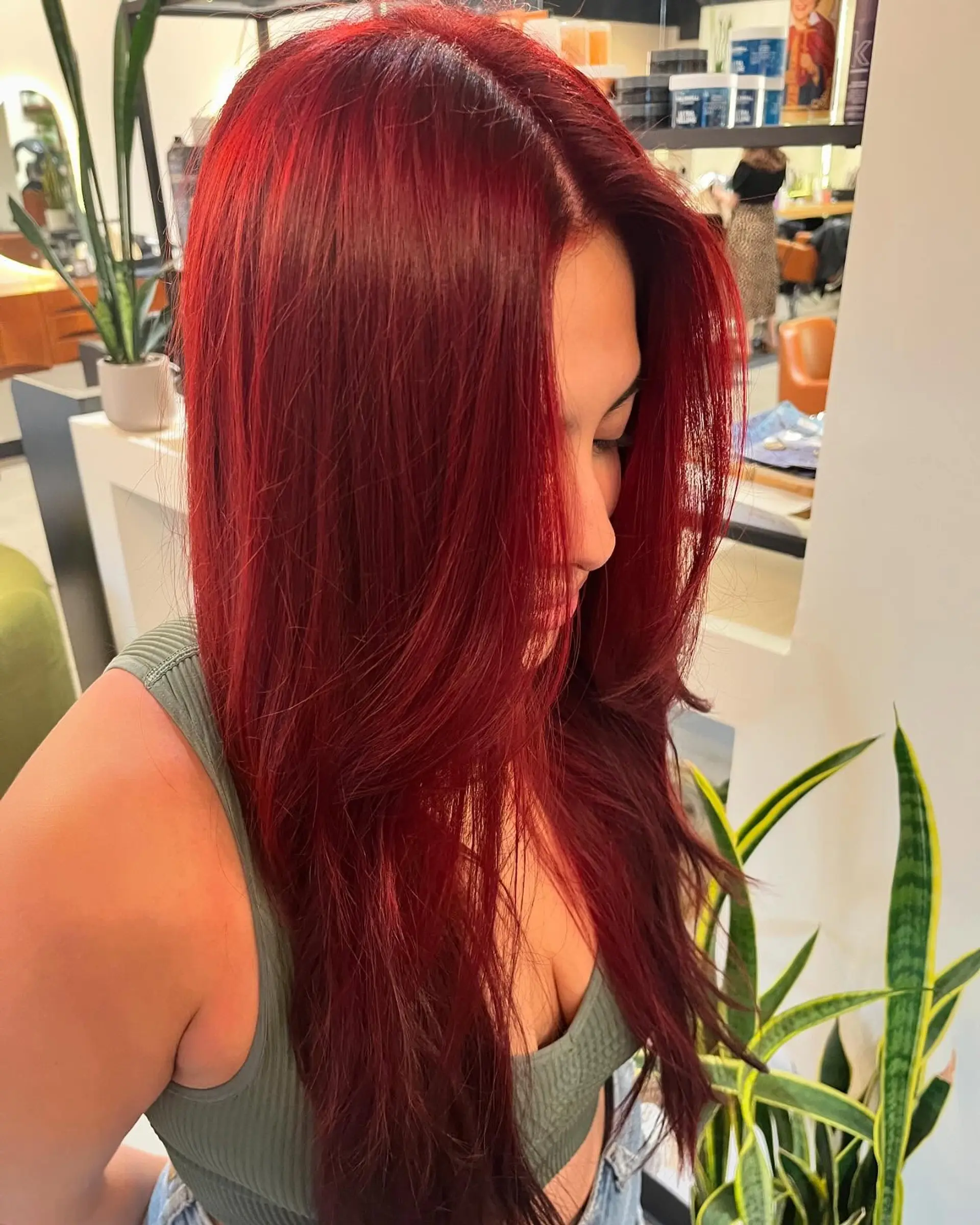A bold, saturated crimson red all-over color styled straight with soft face-framing layers. 1