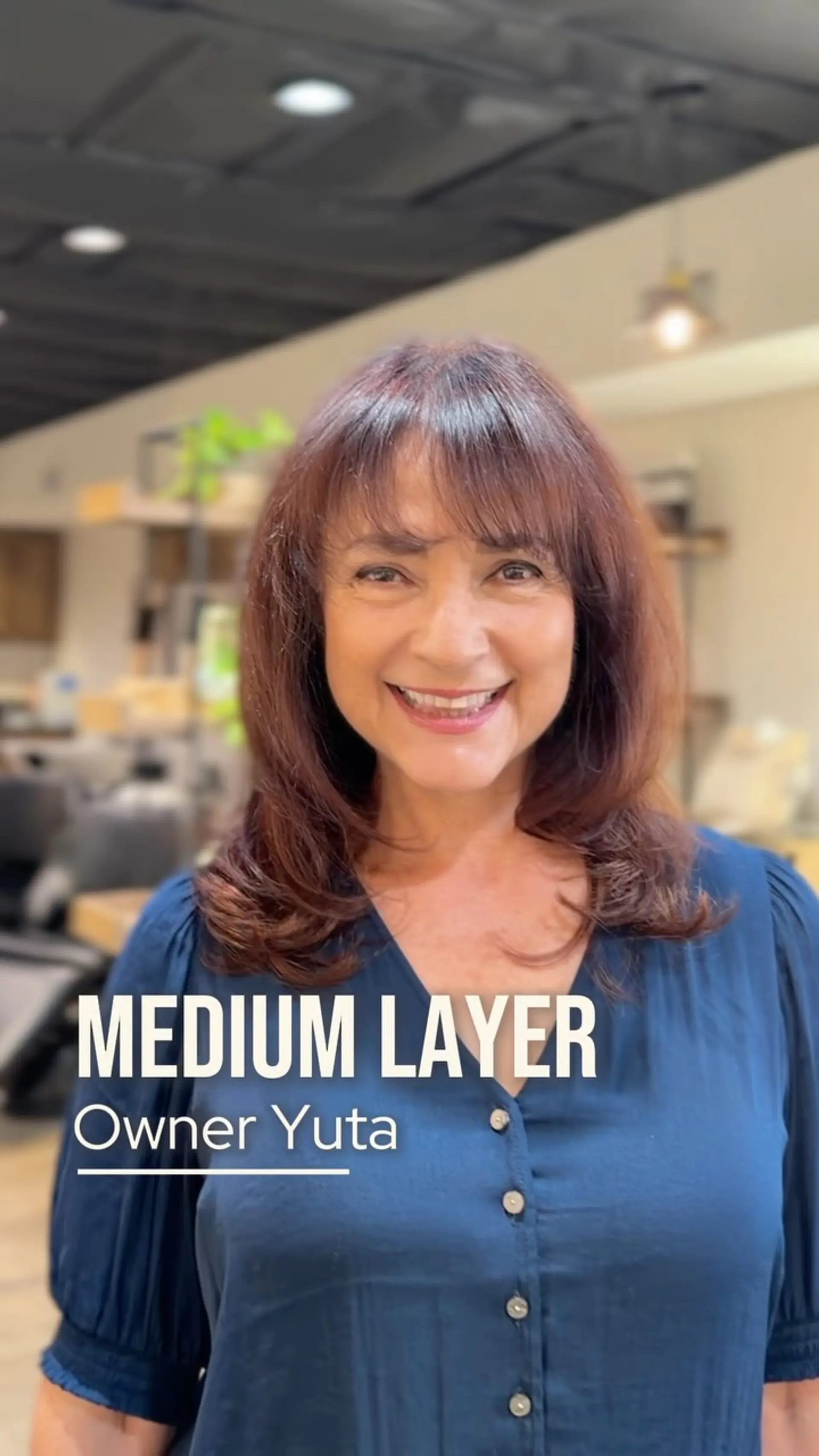 A medium-length layered haircut featuring wispy eyebrow-grazing bangs and softly curled ends. 1