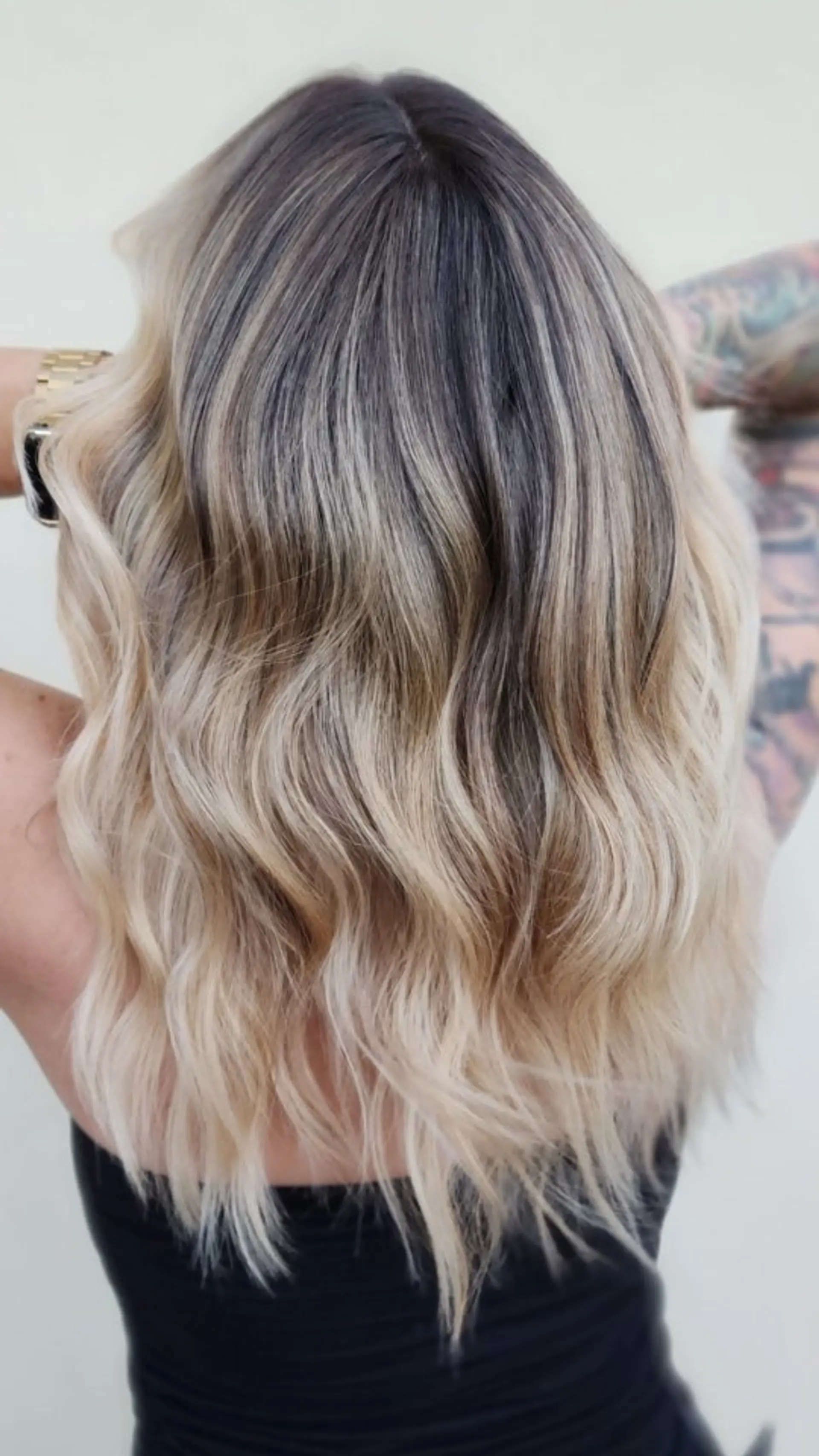 Medium-length wavy hair featuring a seamless blonde balayage with a contrasting dark shadow root and soft tousled waves. 1