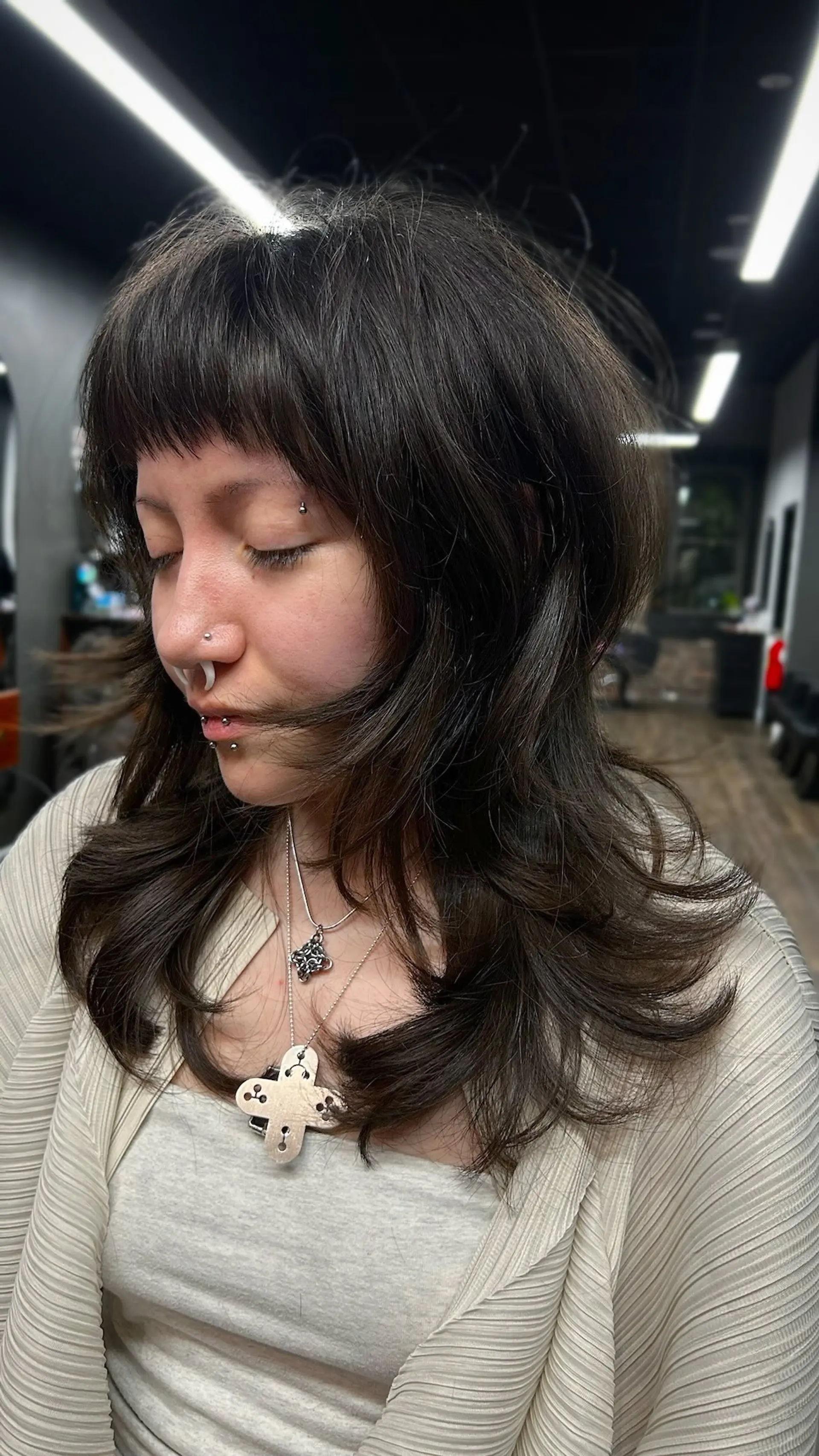 A heavily layered, modern shag haircut featuring textured baby bangs and flipped-out, face-framing layers. 1