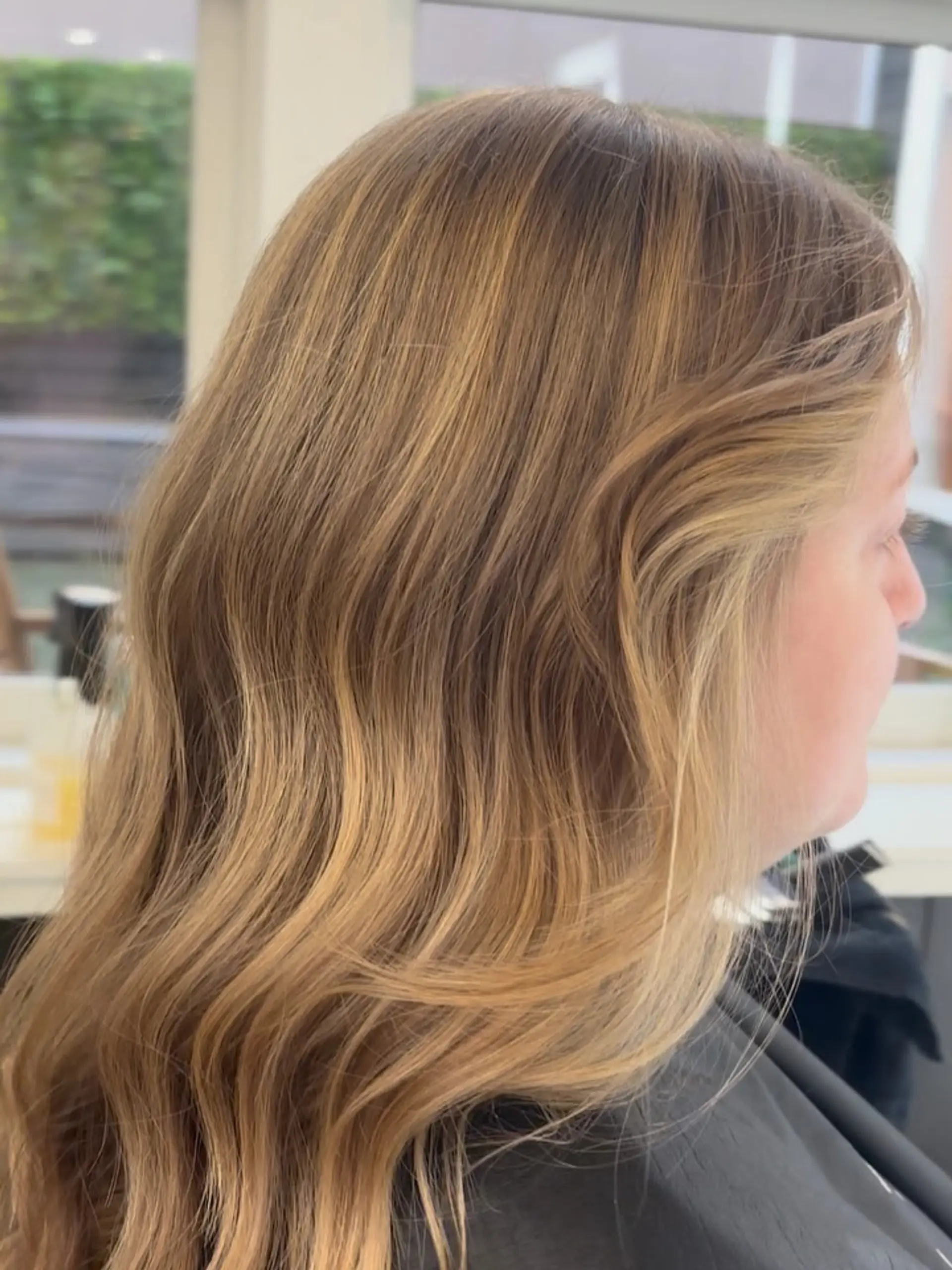 Medium-length golden blonde hair styled in soft, smooth salon waves with warm dimensional highlights. 1
