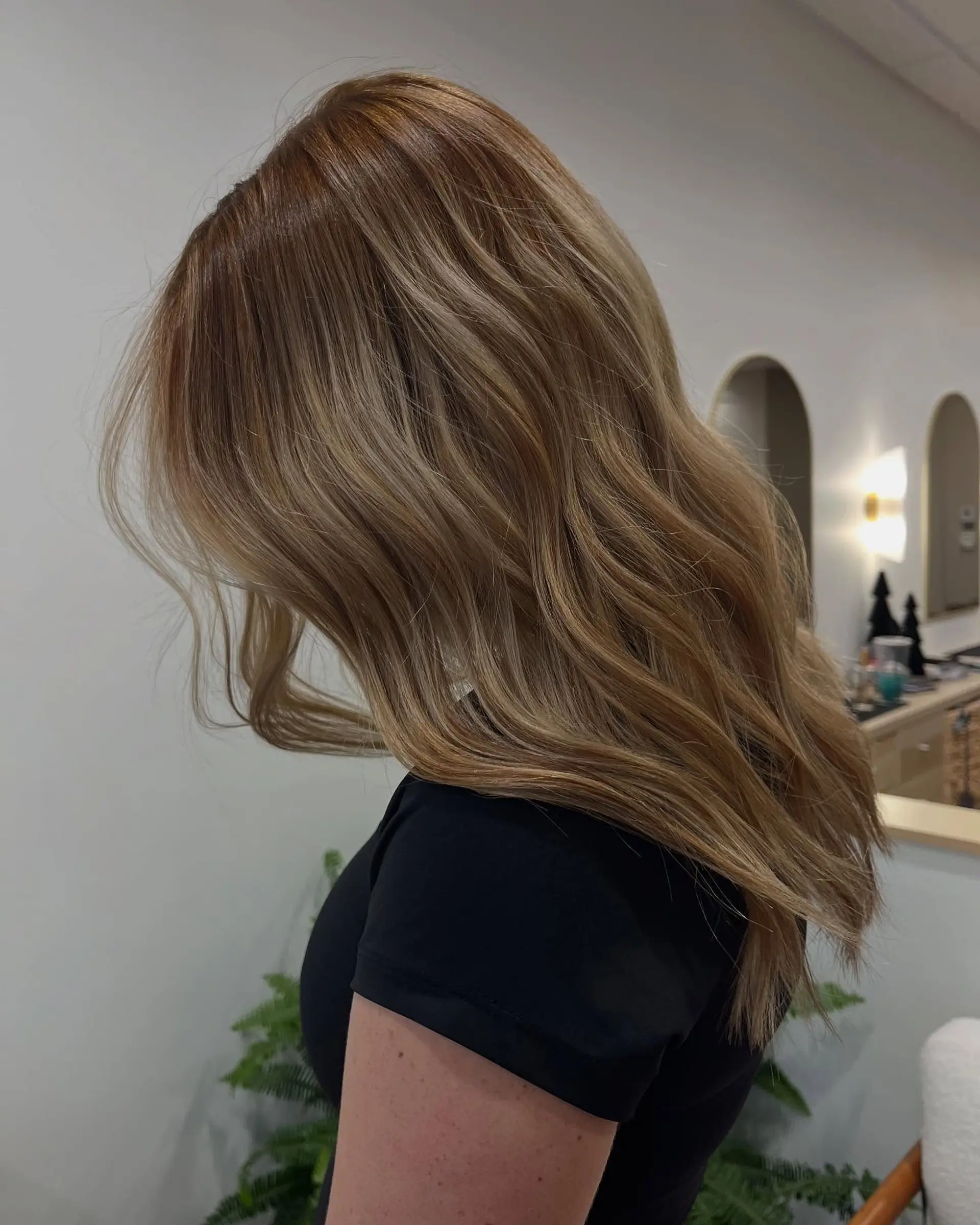 Long dimensional honey blonde hair styled with soft, natural waves. 1