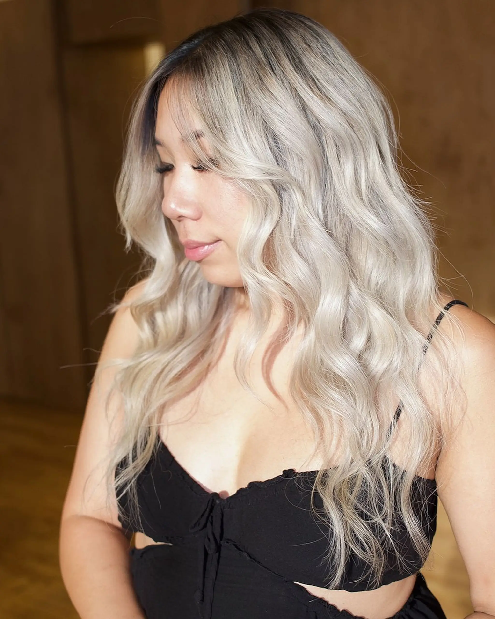 Long, wavy, platinum blonde and silver hair with soft waves, middle parting, face-framing layers, and subtle root shadow.