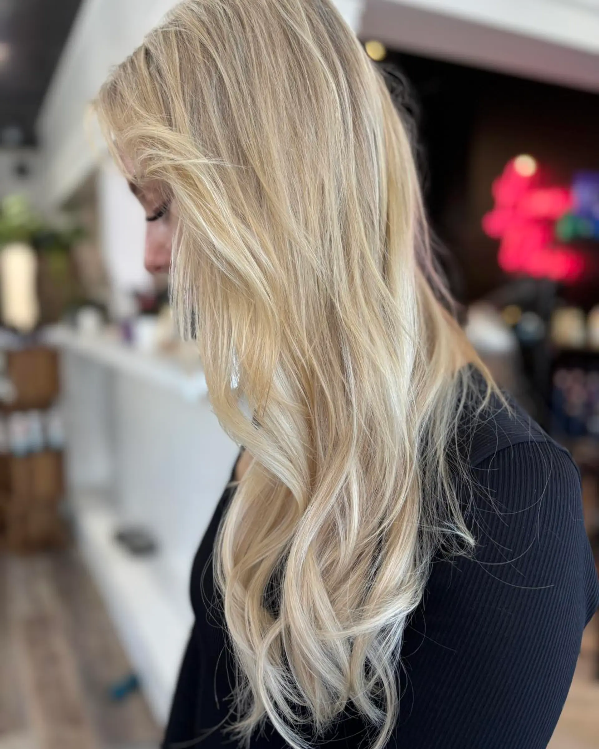 Long dimensional blonde hair styled in soft, cascading waves. 1