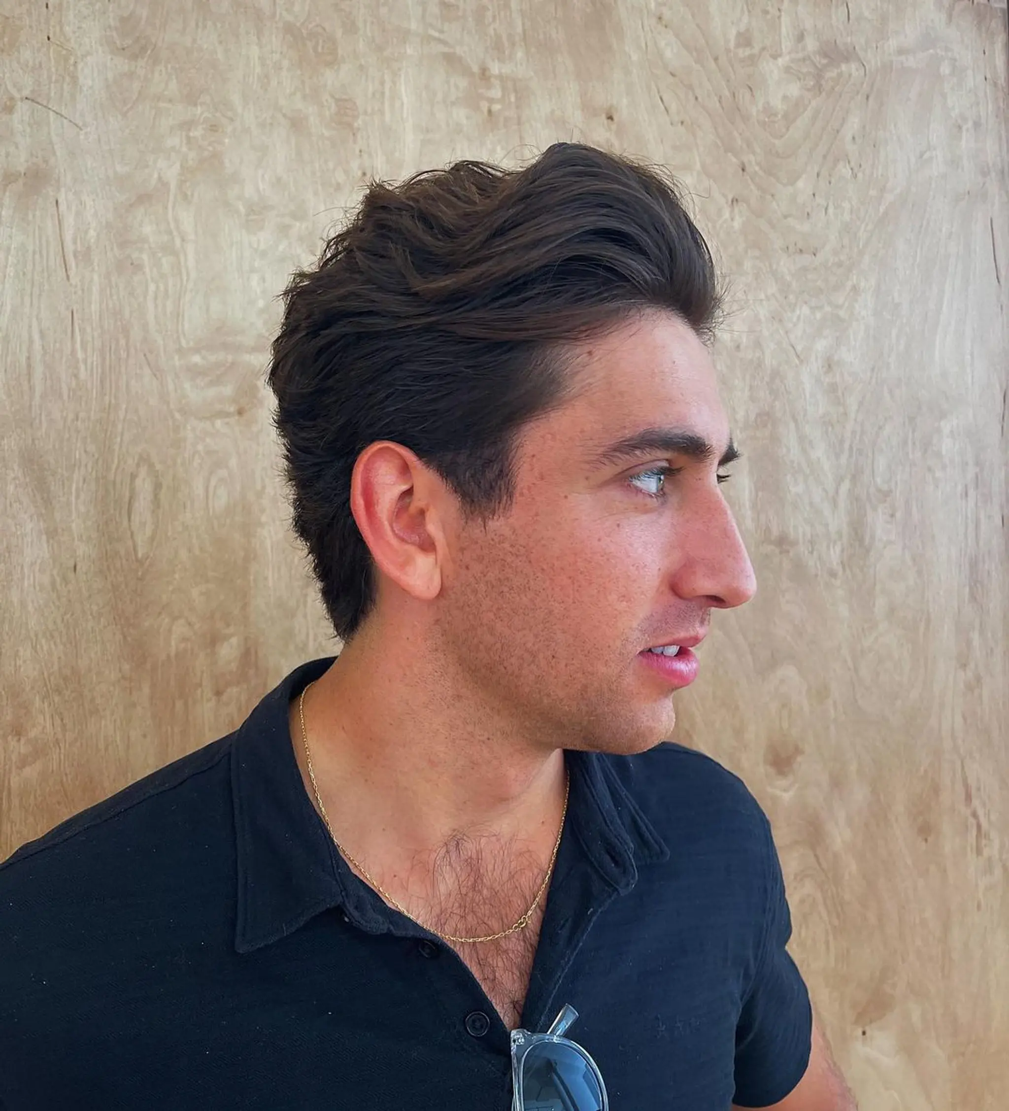 Medium-length wavy dark brown hair styled with natural volume and a side-swept arrangement, creating a windswept, textured flow that exudes an effortless and elegant look.