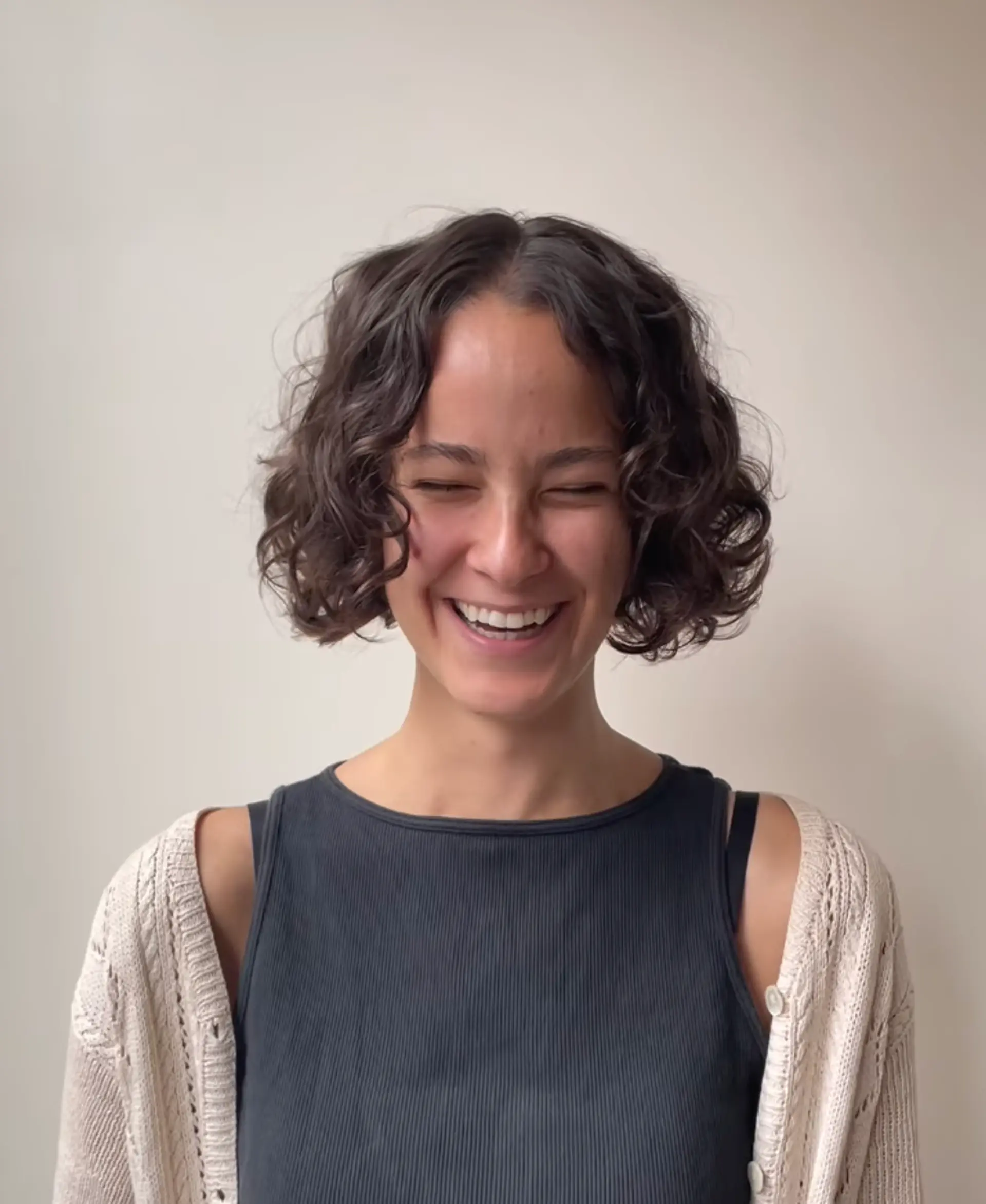 The short bob is enhanced by voluminous, defined curls. The natural dark brown tone adds depth and dimension to this playful, textured look. 2