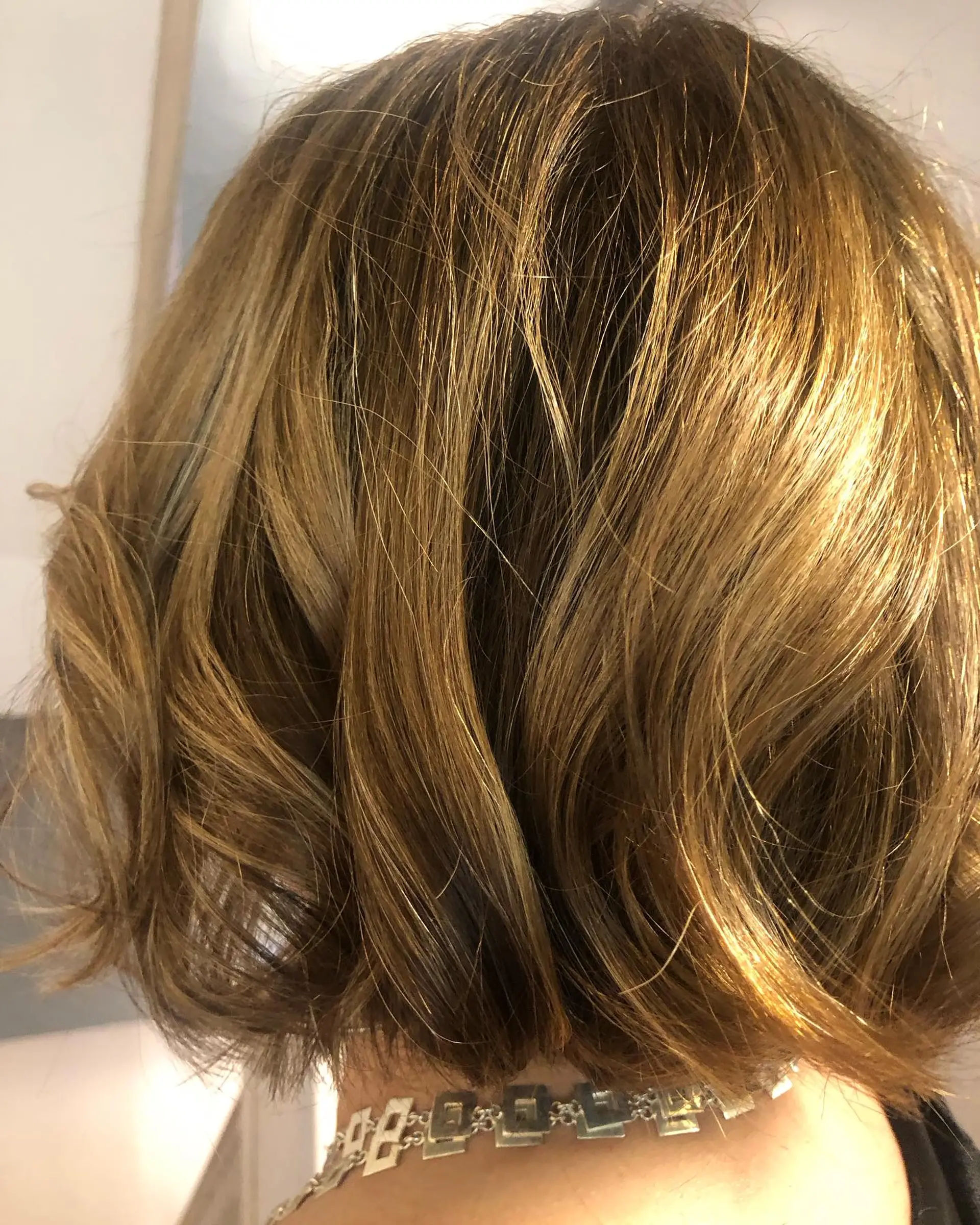 A textured short bob styled with loose, relaxed waves and a glossy finish. 1