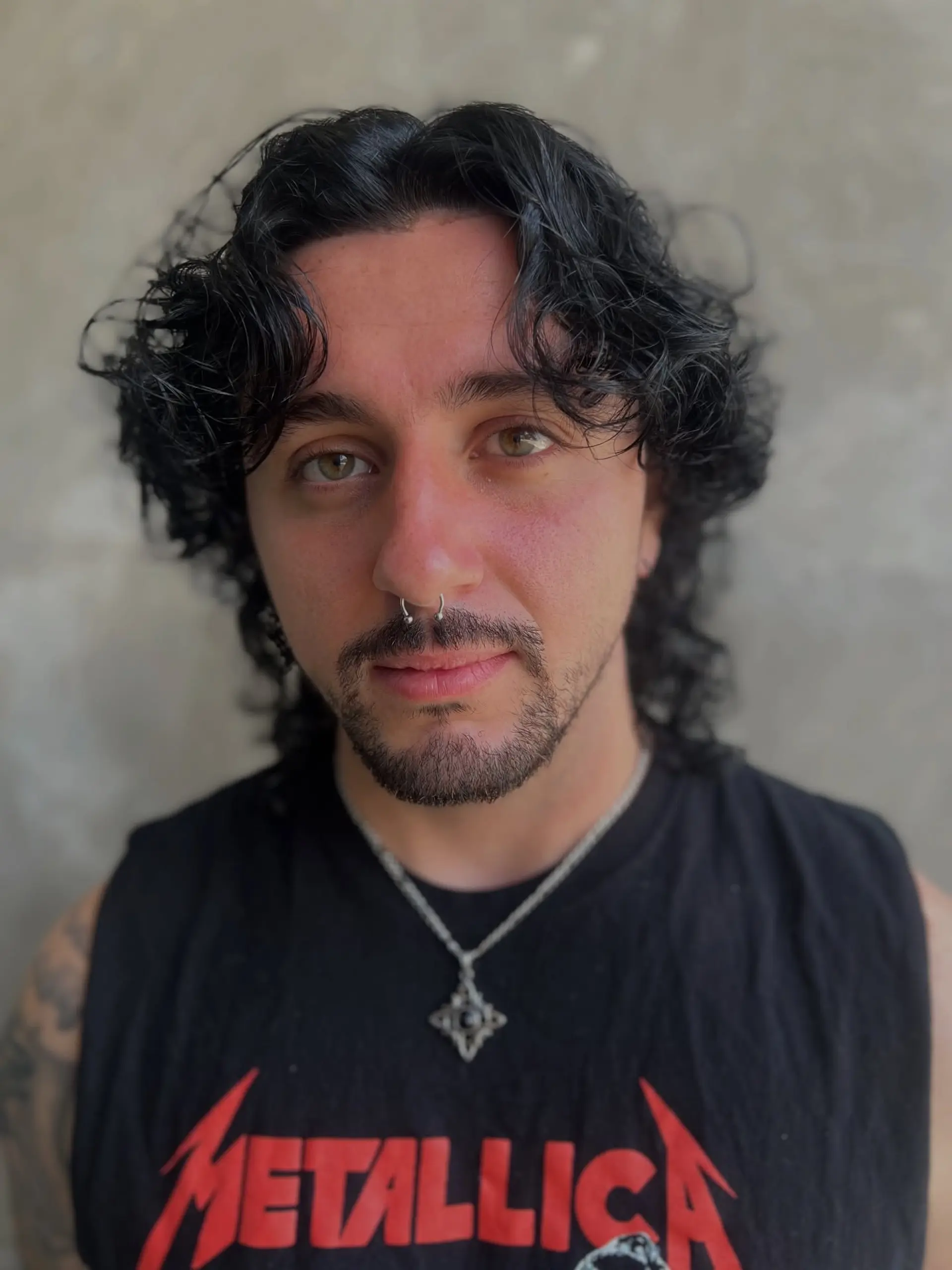 A textured curly wolf cut with natural volume, face-framing fringe, and layered tapering down the neck. 1