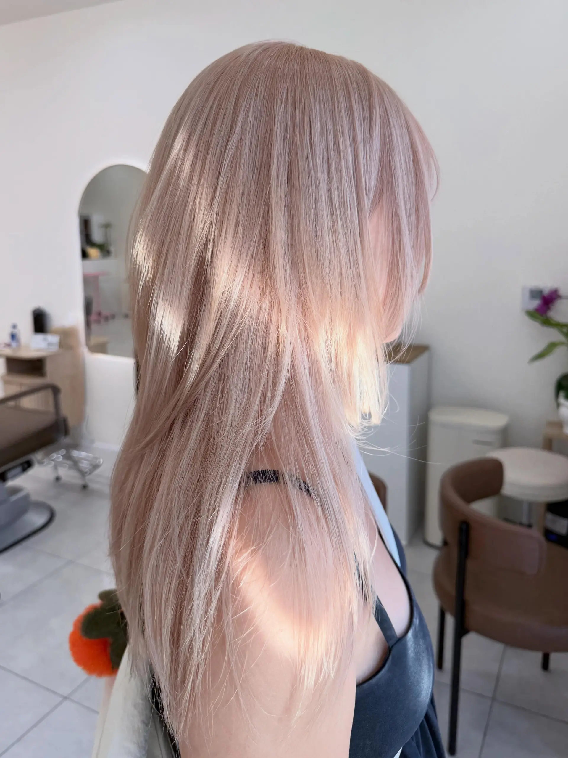 Straight, softly layered long hair colored in a luminous champagne and mahogany gold blonde shade. 1
