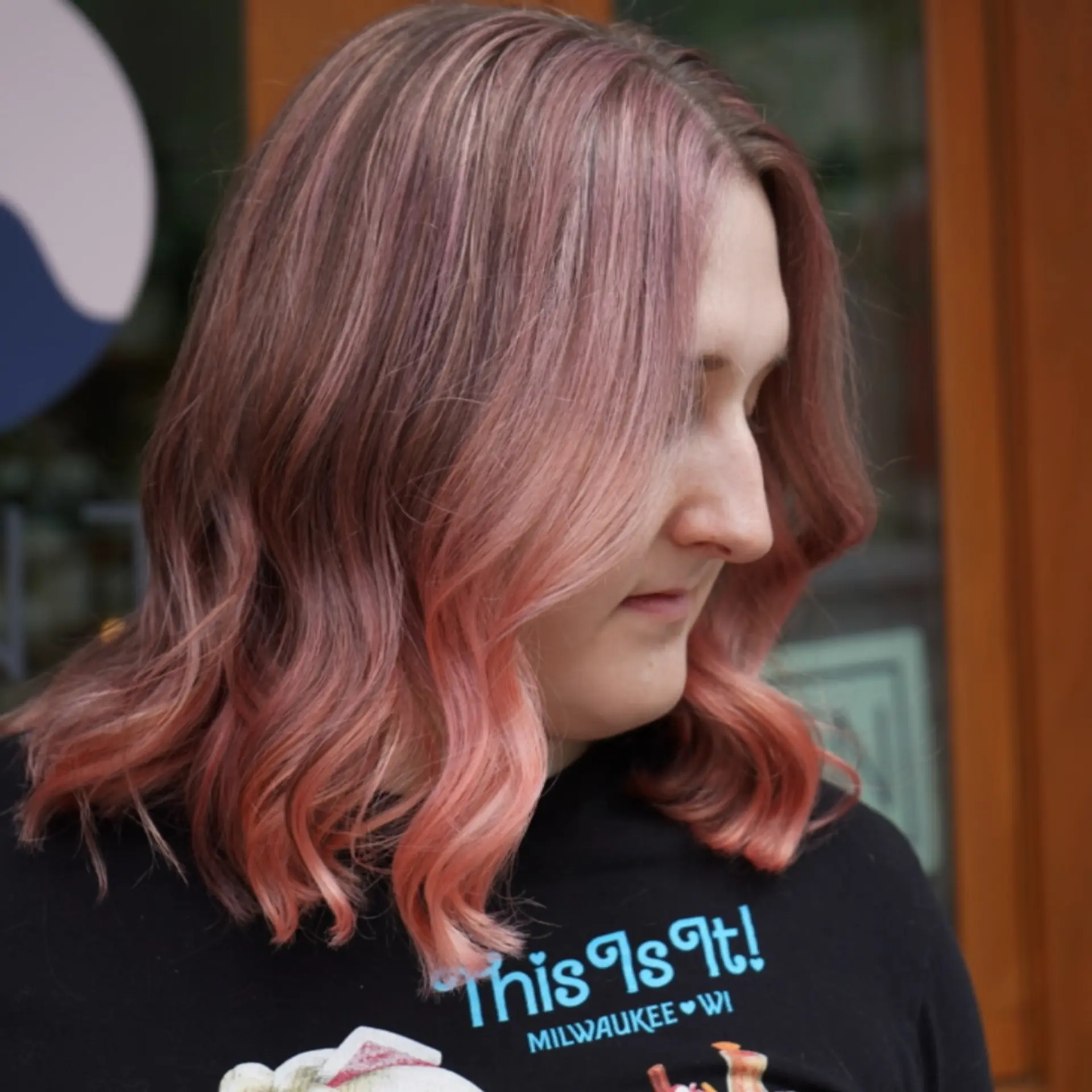 A textured shoulder-length lob styled with loose, relaxed waves and a subtle face frame, finished in a blended pastel pink tone. 1