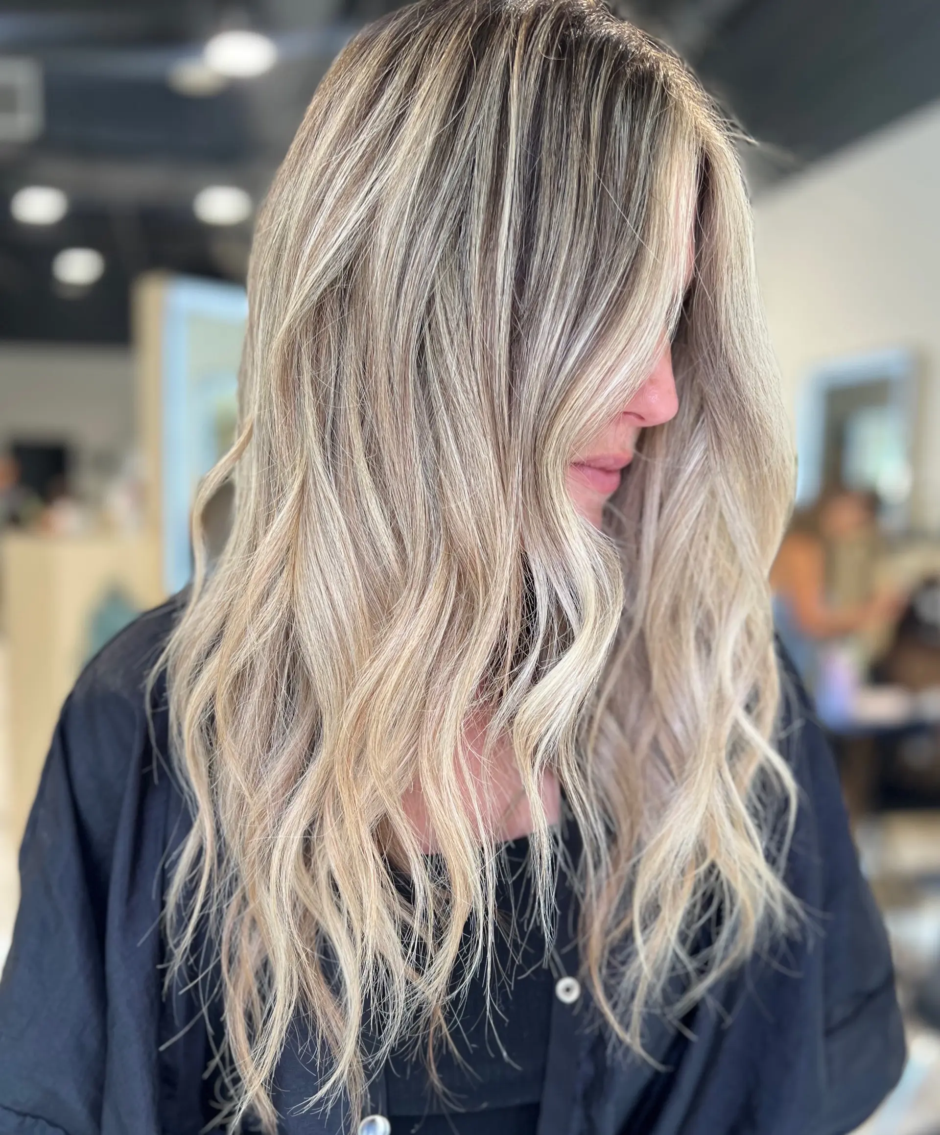 Long dimensional blonde hair styled into effortless, loose waves. 1