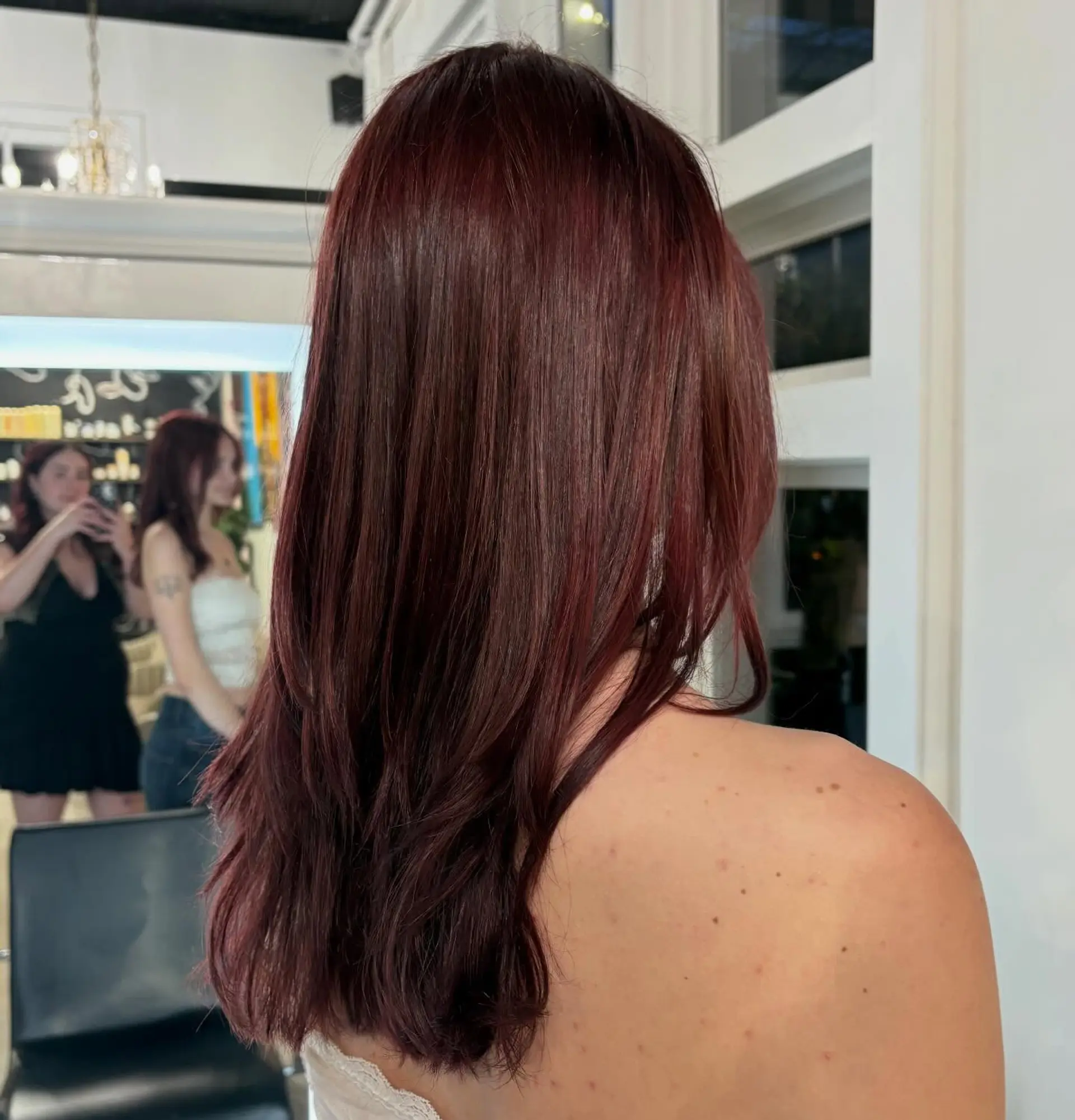 Long, sleek deep mahogany-red hair styled with a smooth blowout and subtle texture at the ends. 1