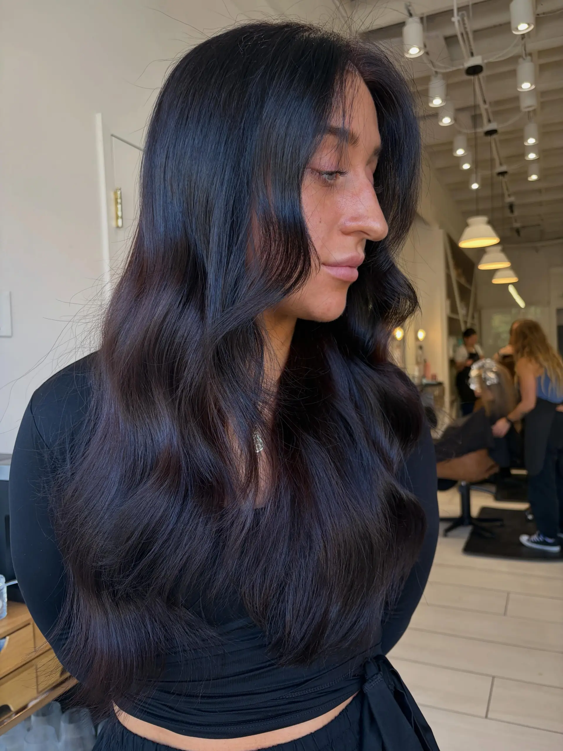 Long, glossy cherry cola brunette hair styled in loose, soft waves with curtain face-framing layers. 1