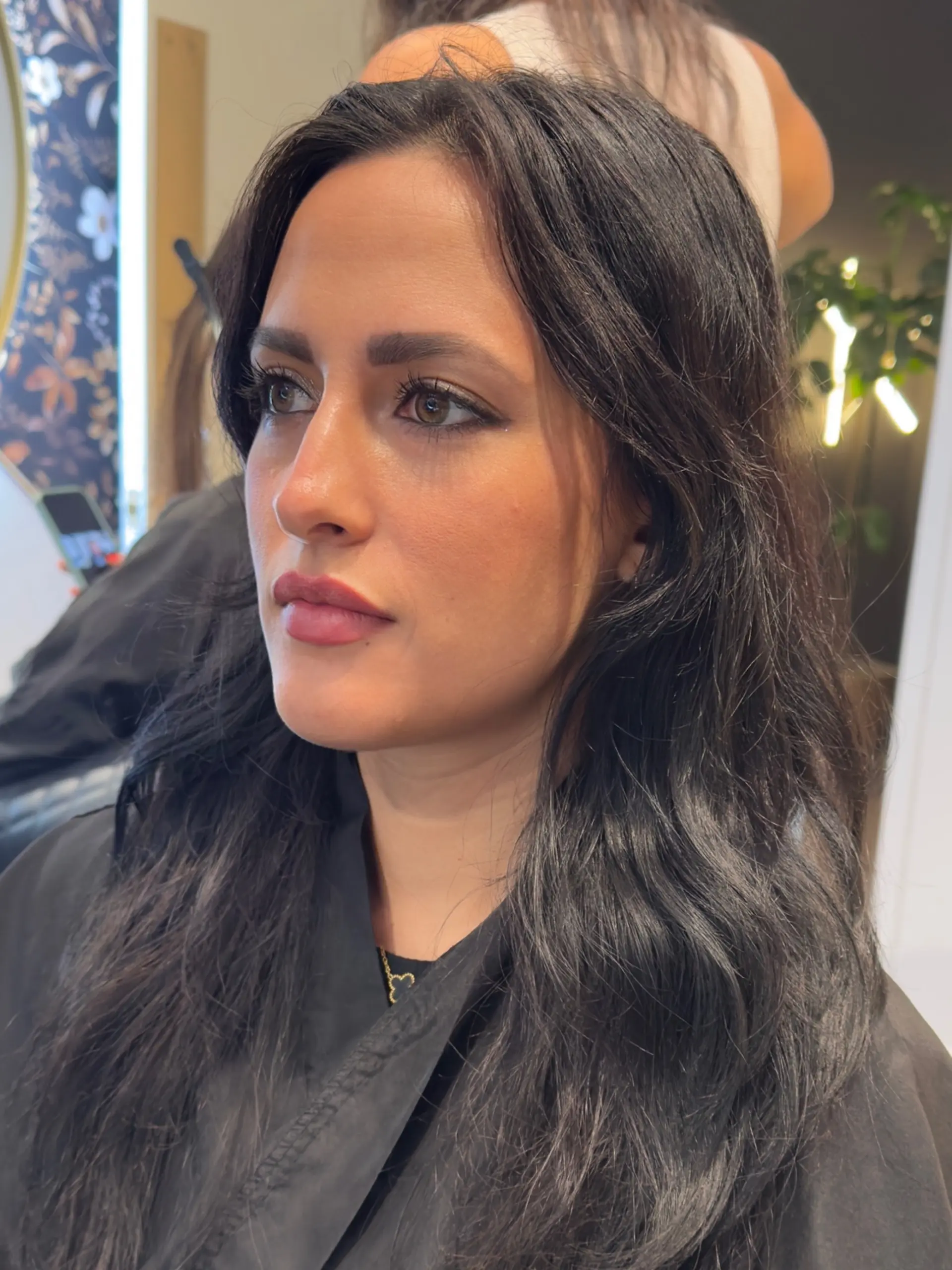 A long dark haircut cut with soft face-framing layers and styled with natural-looking waves. 1