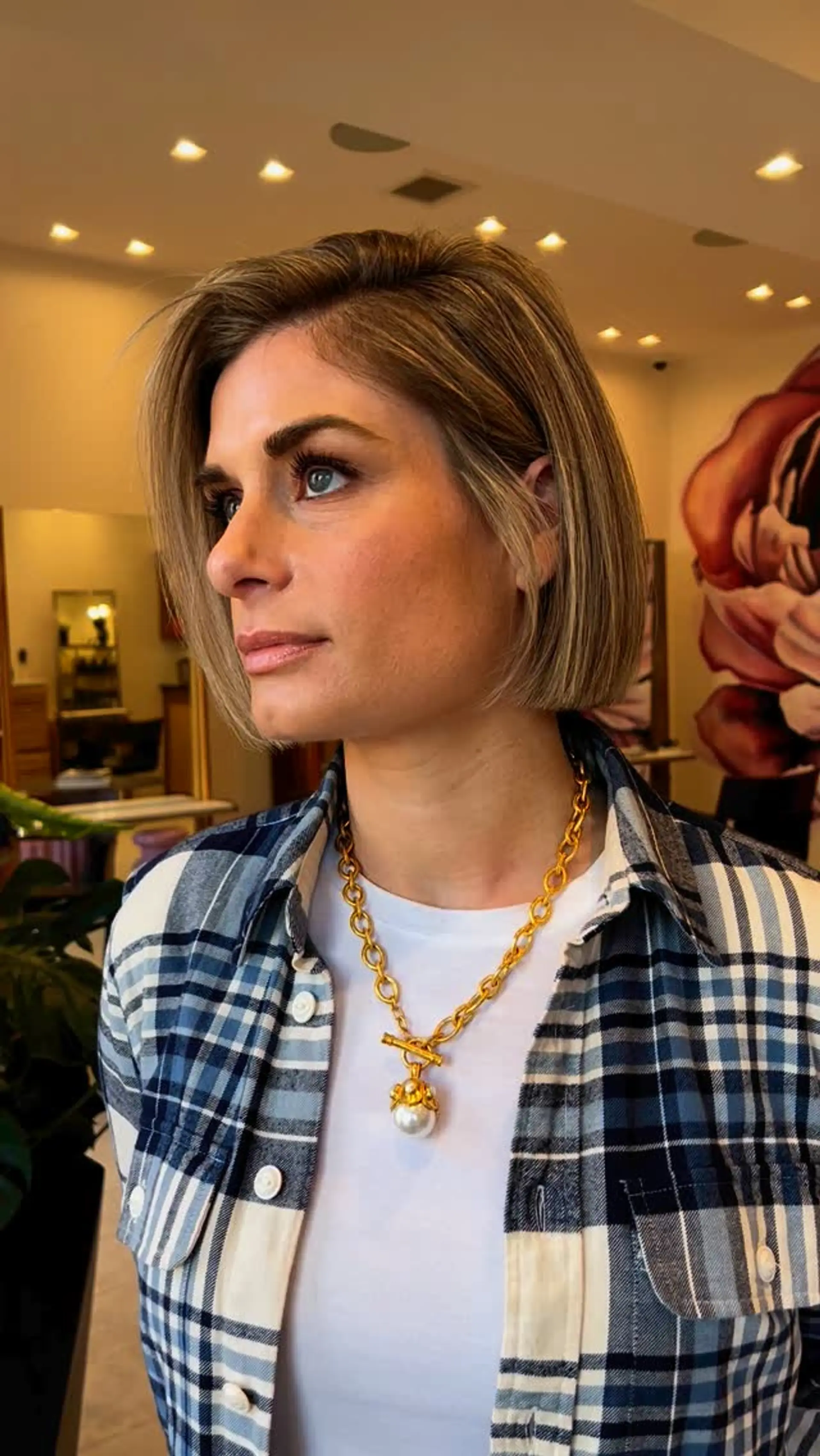 A sleek, chin-length blunt bob haircut styled straight with fine blonde highlights and a side part. 1