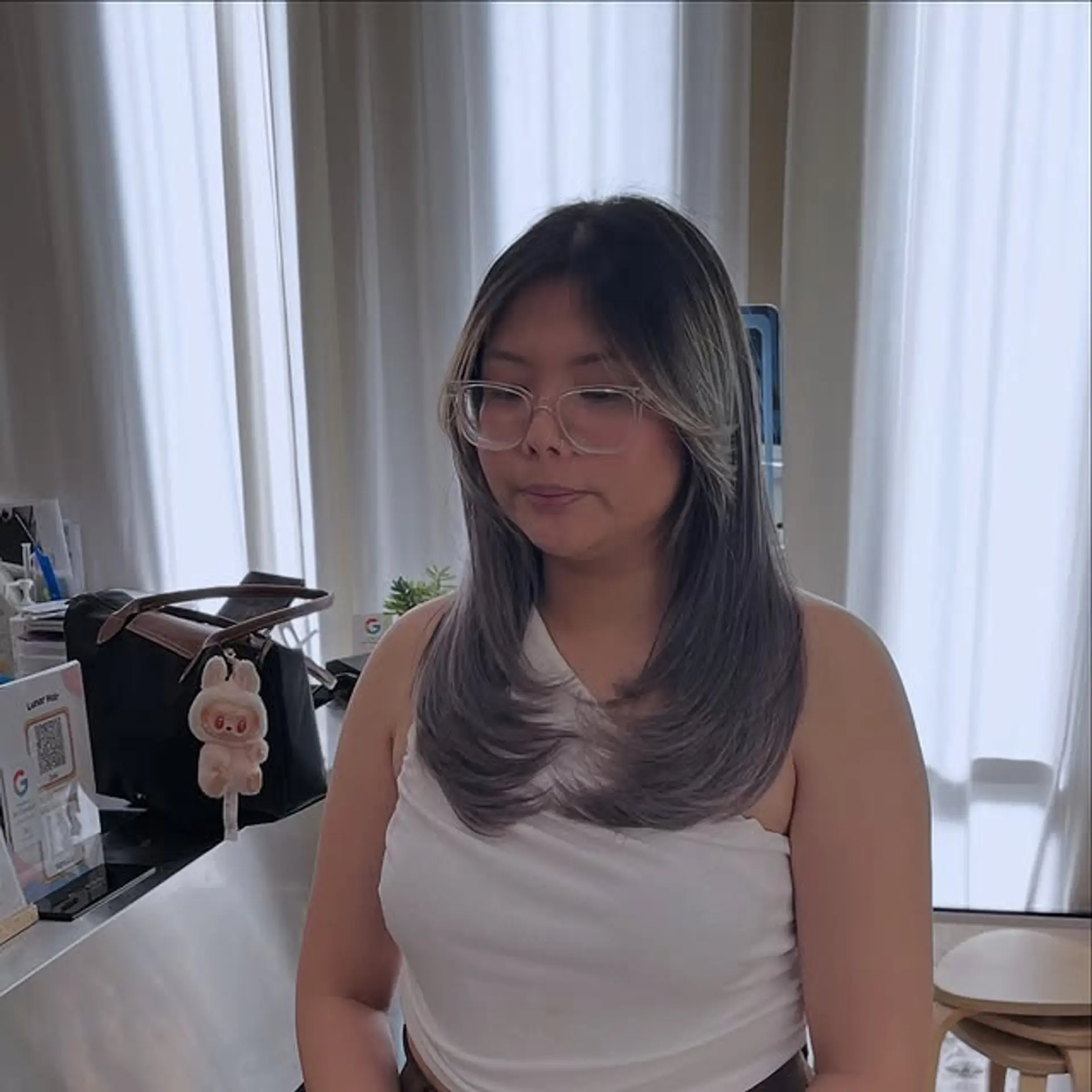 A medium-length layered hairstyle with face-framing layers and a seamless color melt. 1