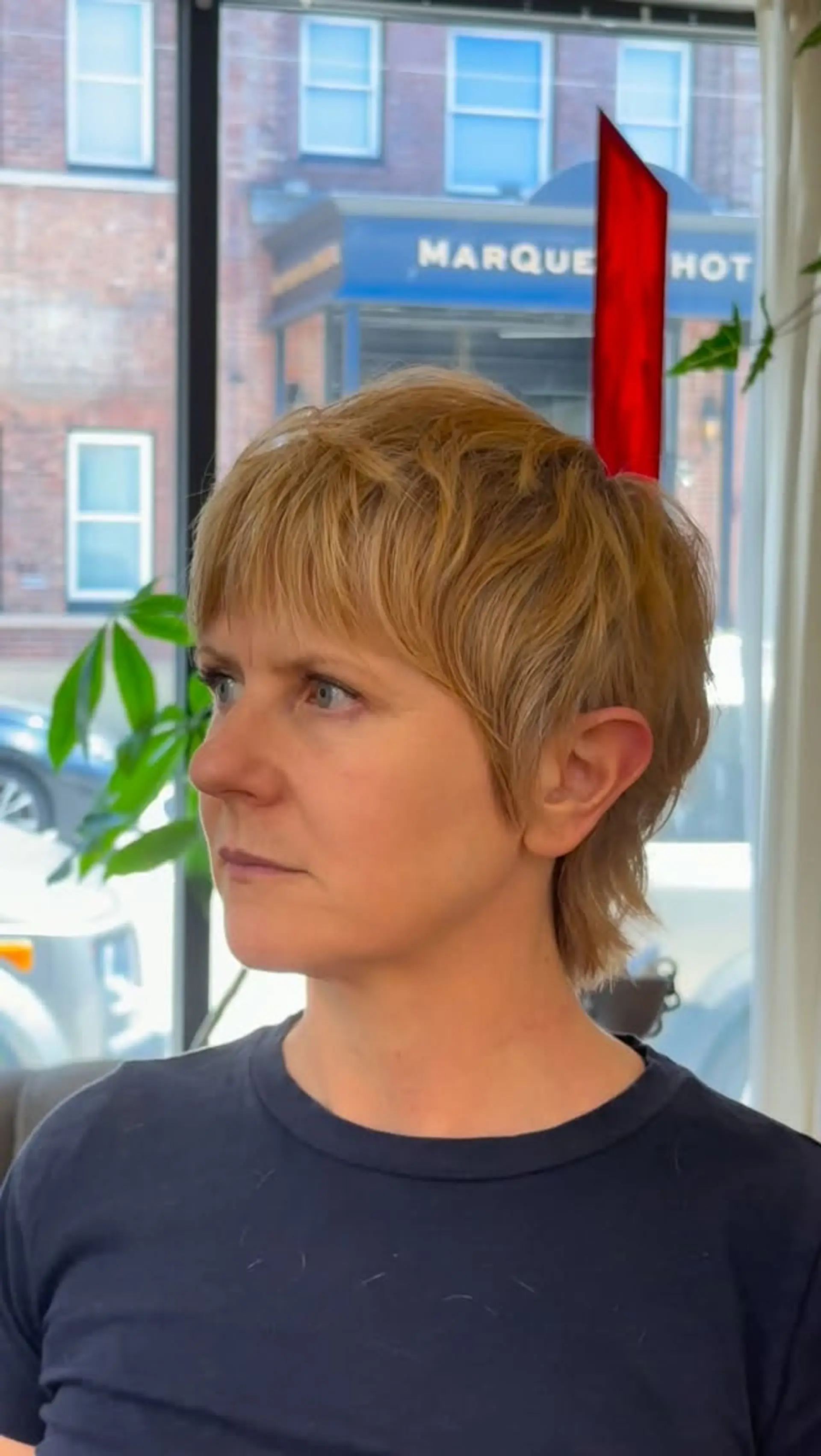 A modern pixie mullet with piecey straight-across bangs, softly layered crown, and a wispy tapered nape. 1