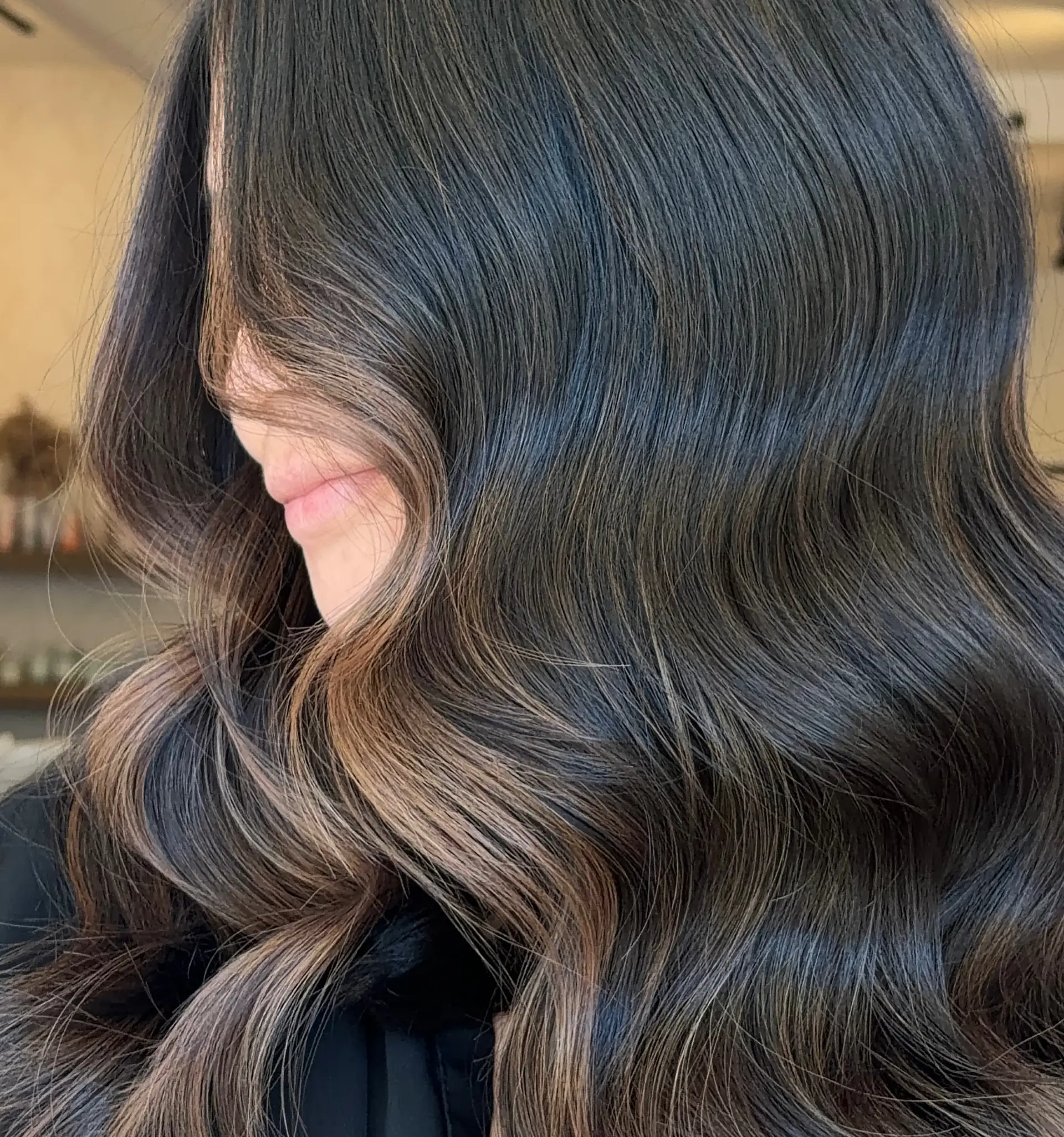 Glossy, rich dark espresso hair styled into soft, elegant waves with seamless caramel dimension. 1