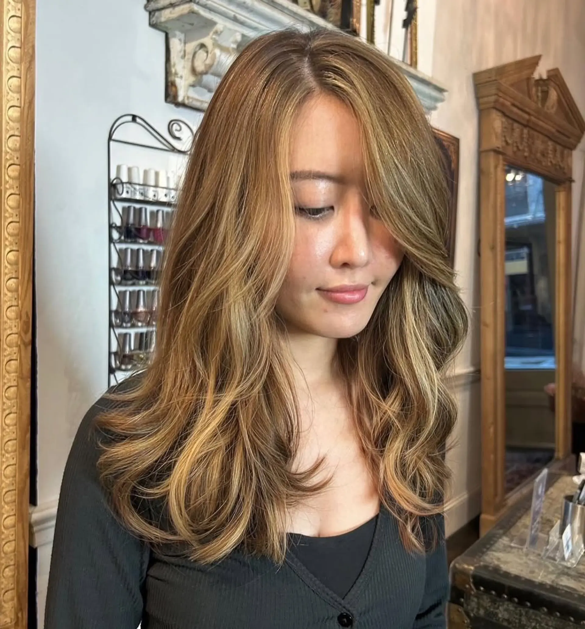 Beautifully styled long, wavy hair with light brown and golden blonde highlights, featuring soft curls and natural volume for an elegant look. 4