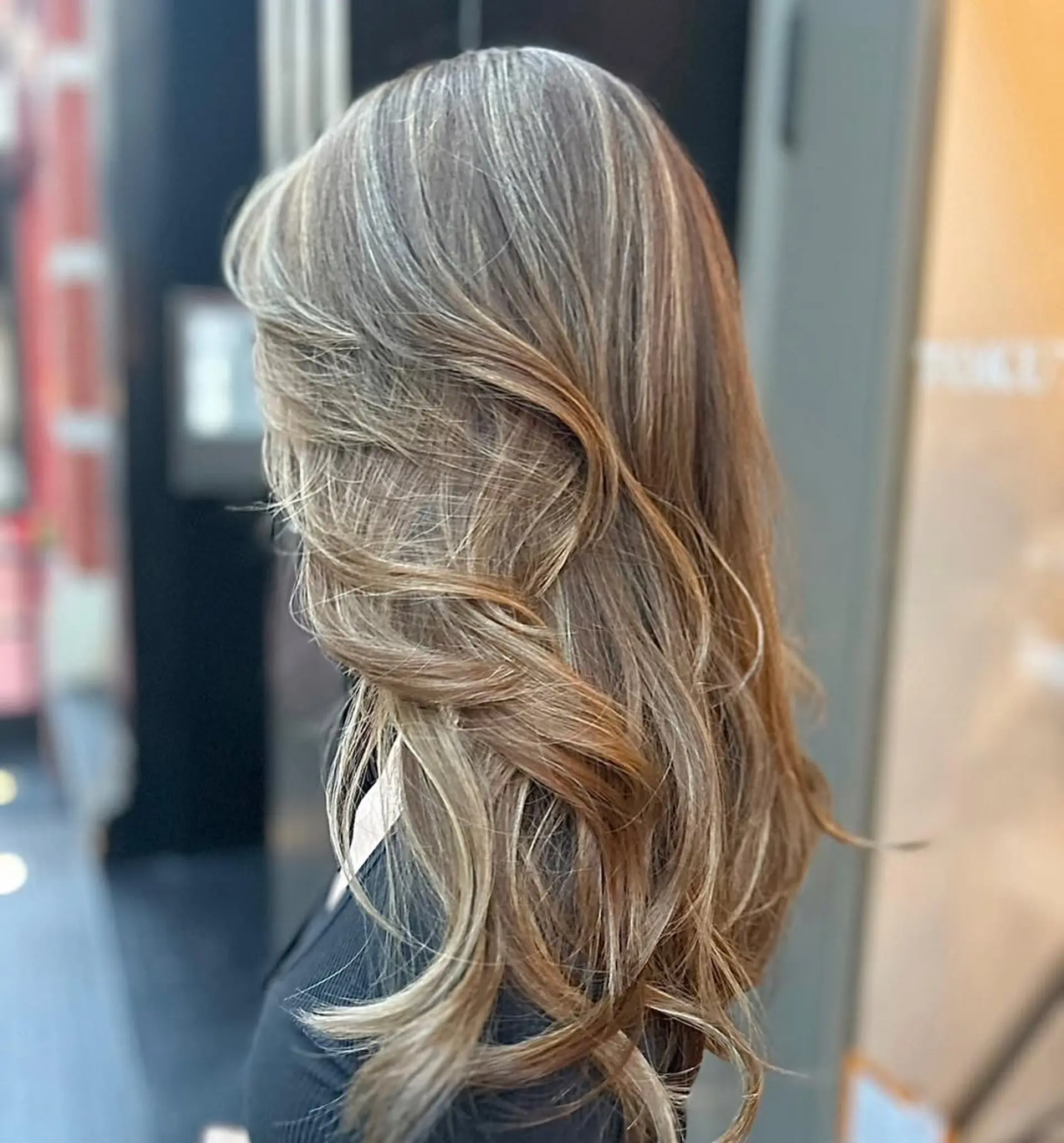 Beautifully styled long, wavy hair with light brown and golden blonde highlights, featuring soft curls and natural volume for an elegant look. 1