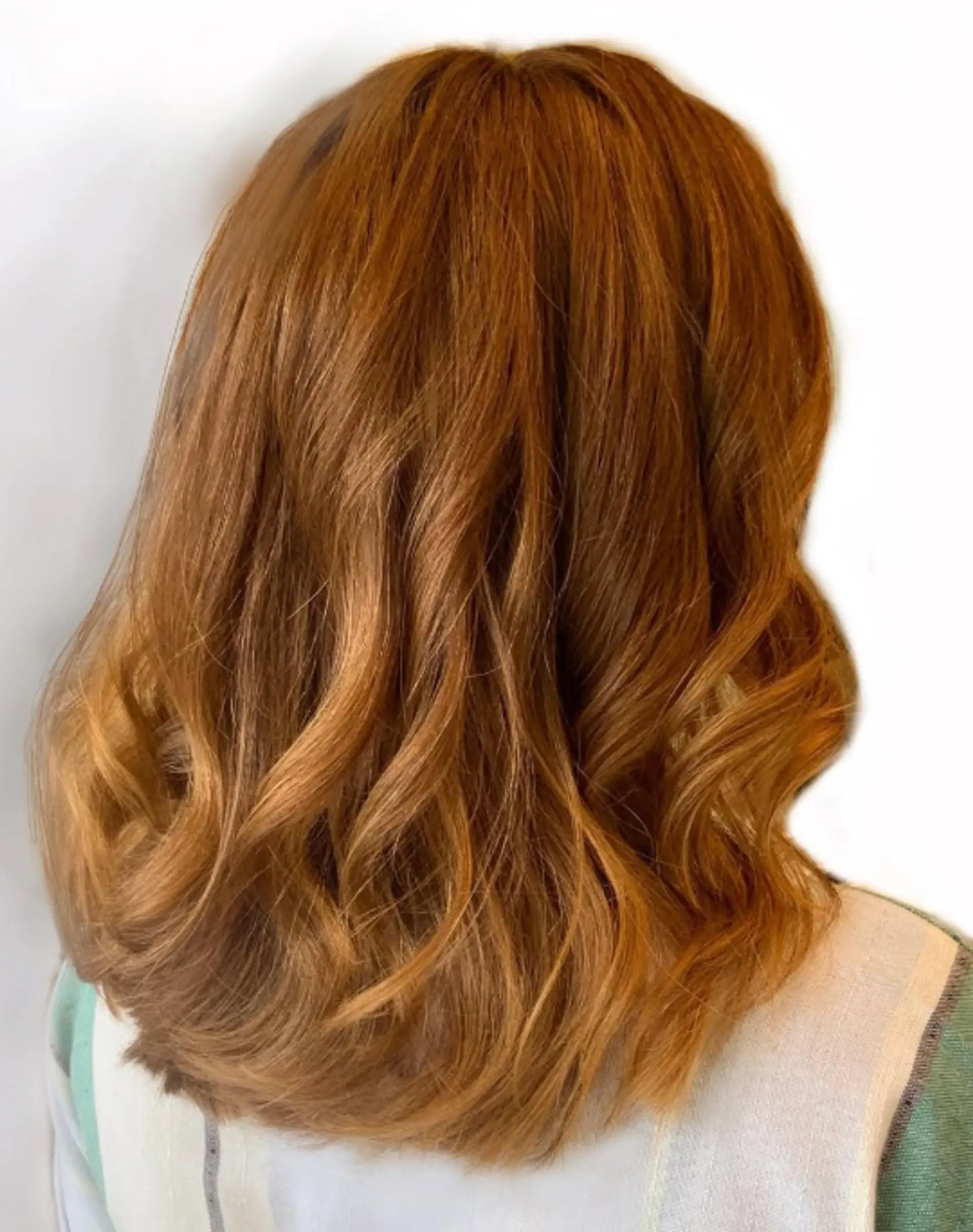 A medium-length wavy hairstyle with flowy waves and layered ends. 1