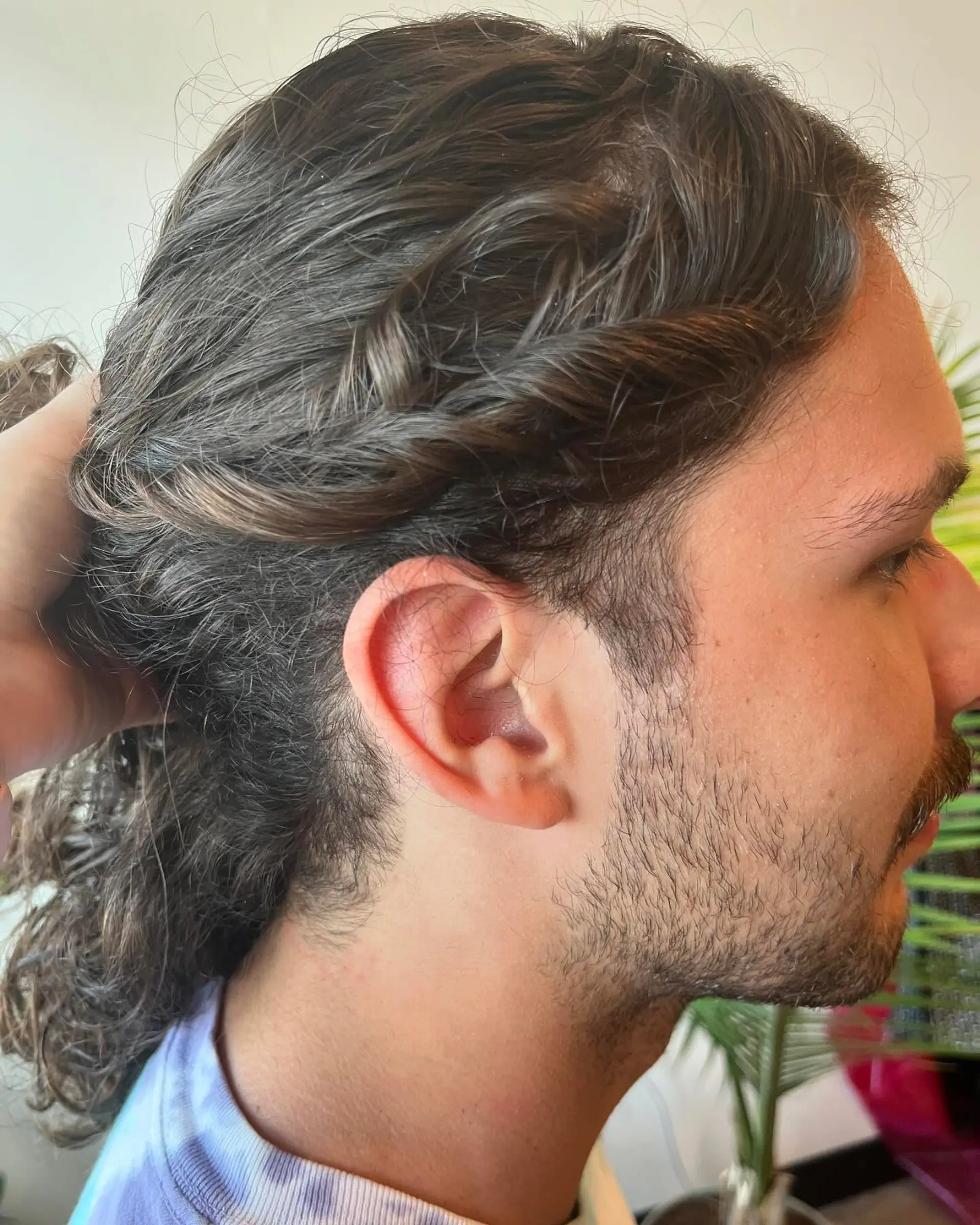 Medium-length curly brown hair styled with a side twist accent along the temple. 1