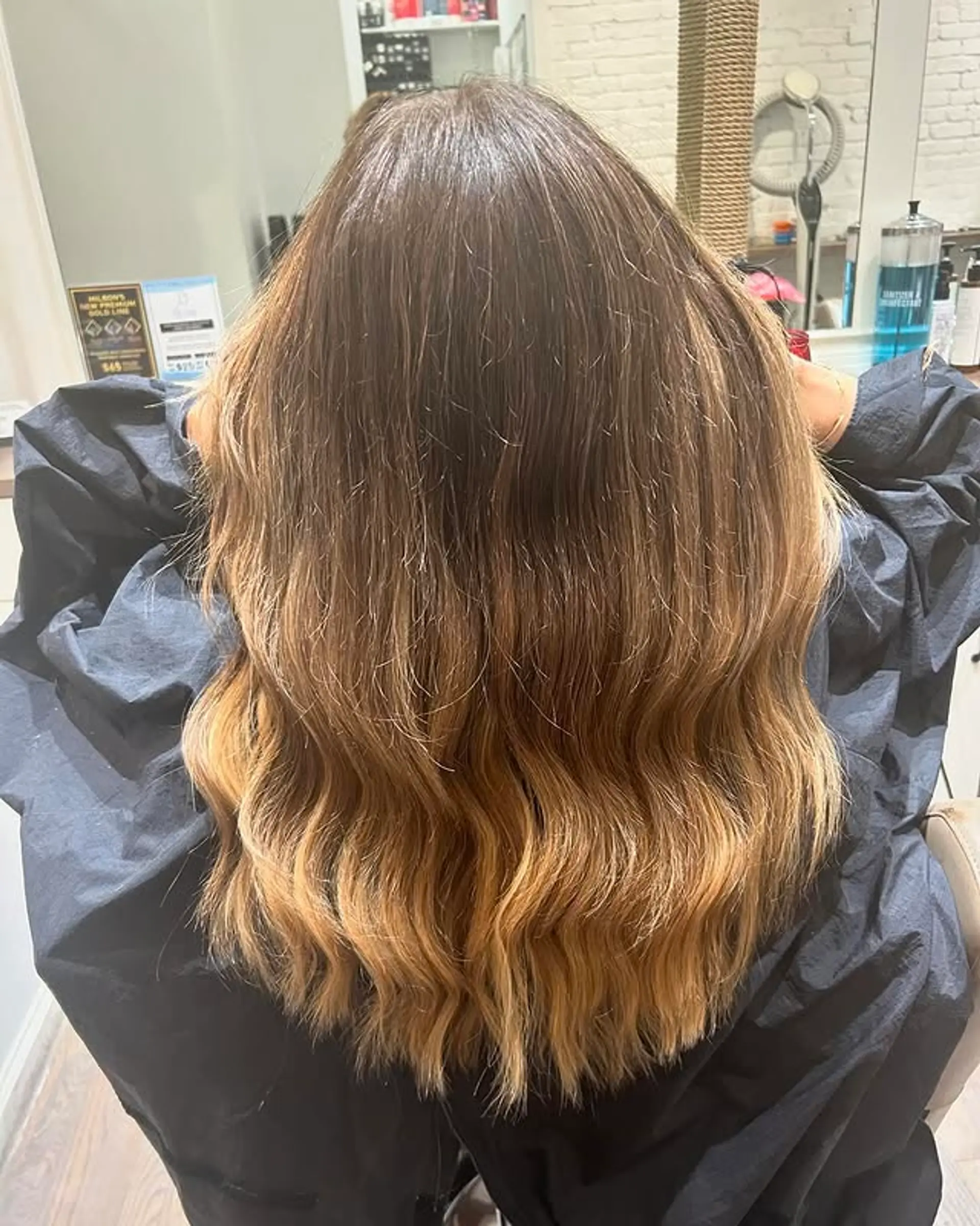 Long, wavy hairstyle featuring a seamless ombre from dark brown to blonde. 1