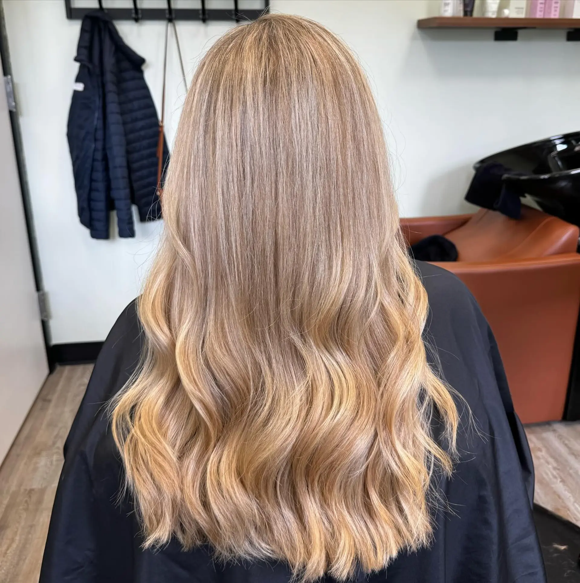 Long golden blonde balayage styled with smooth crown texture and soft waves through the lower lengths. 1