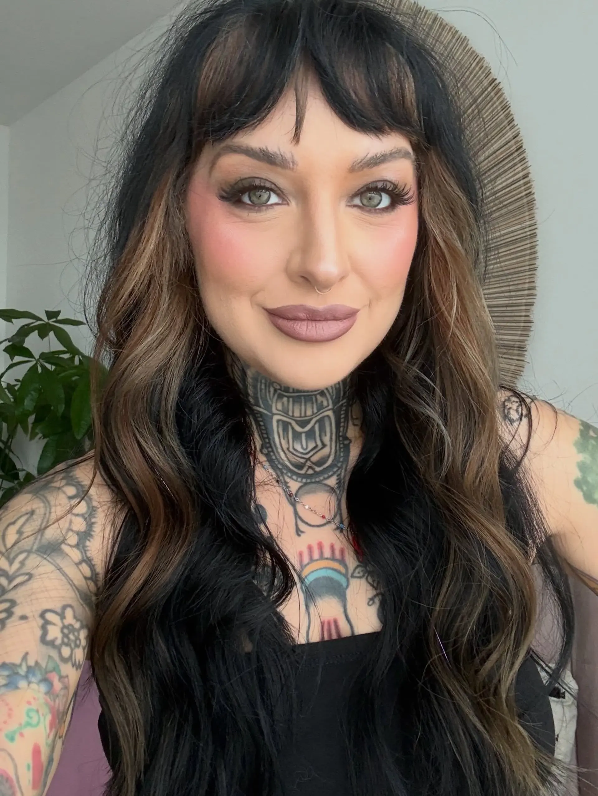 Long layered black hair featuring warm brown peek-a-boo panels, paired with textured bangs and soft waves. 1
