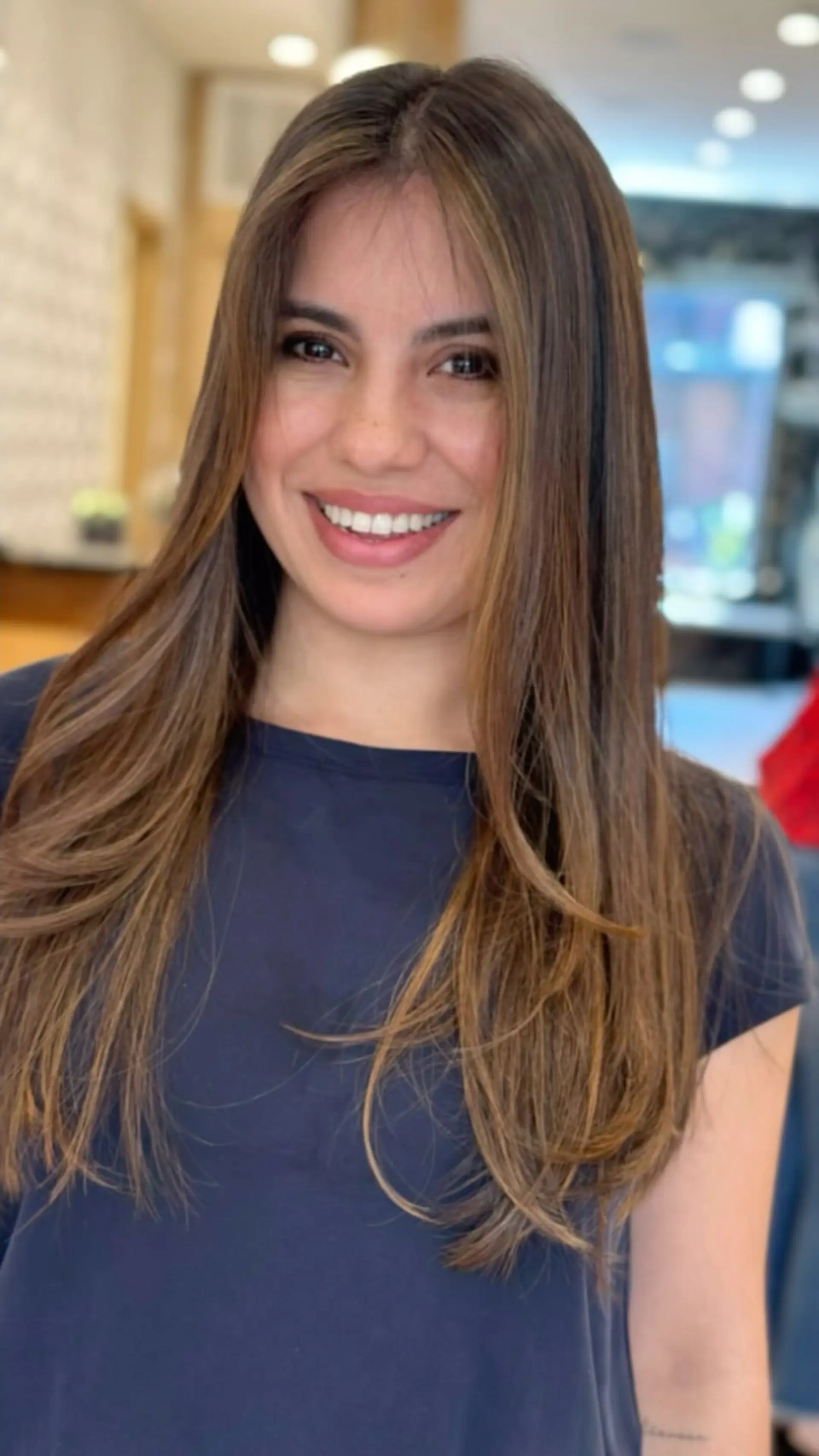 Long smooth brunette hair featuring soft caramel balayage highlights and delicate face-framing layers. 1