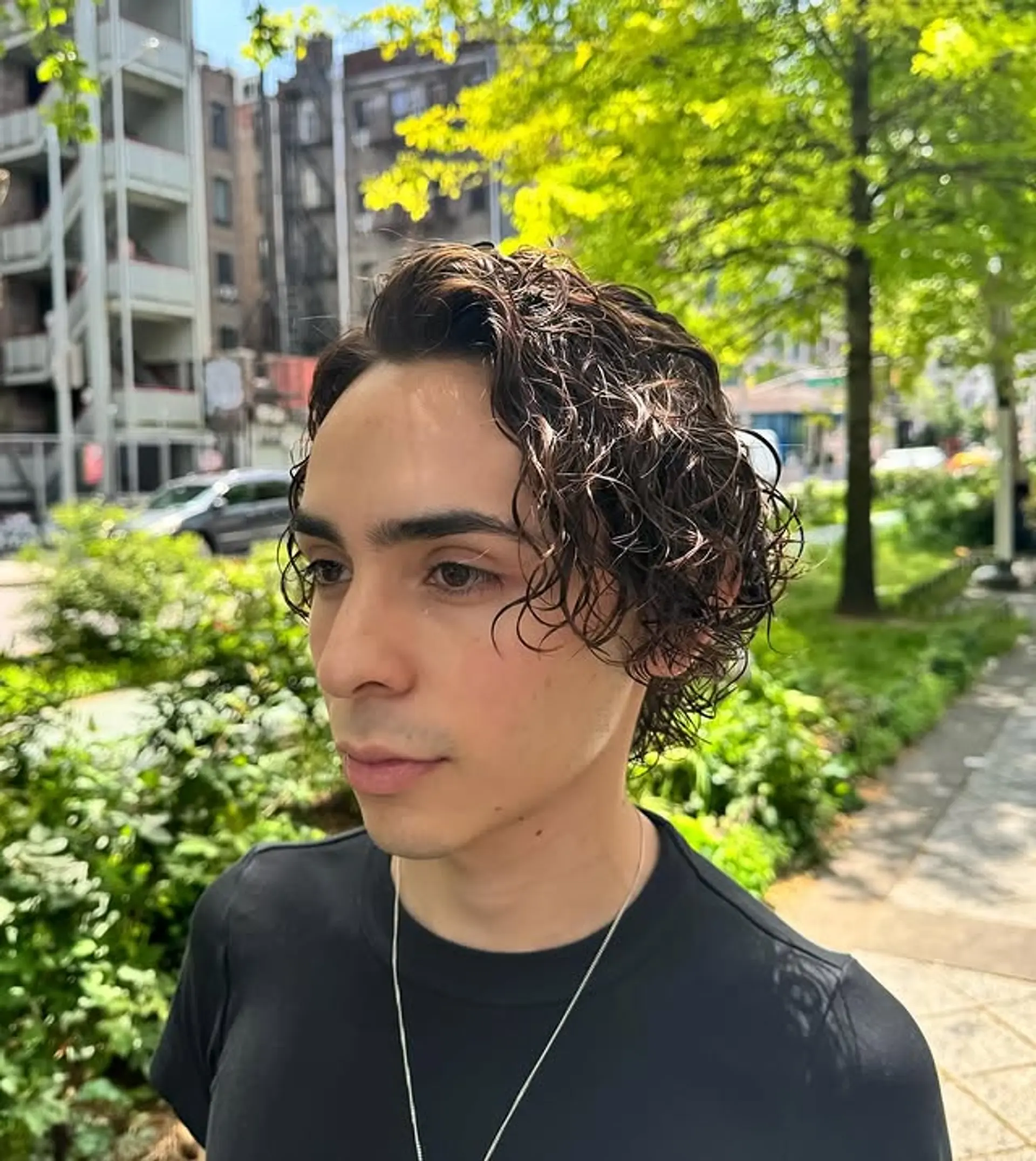 This medium-length curly hairstyle features natural curls styled in a relaxed, bro flow. 1