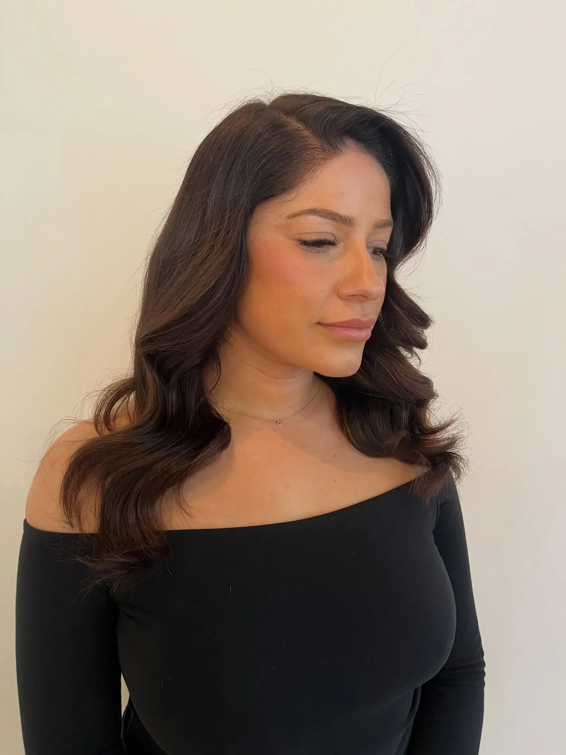 Medium-length dark brown hair styled with an elegant deep side part and smooth, voluminous waves cascading over the shoulders. 1