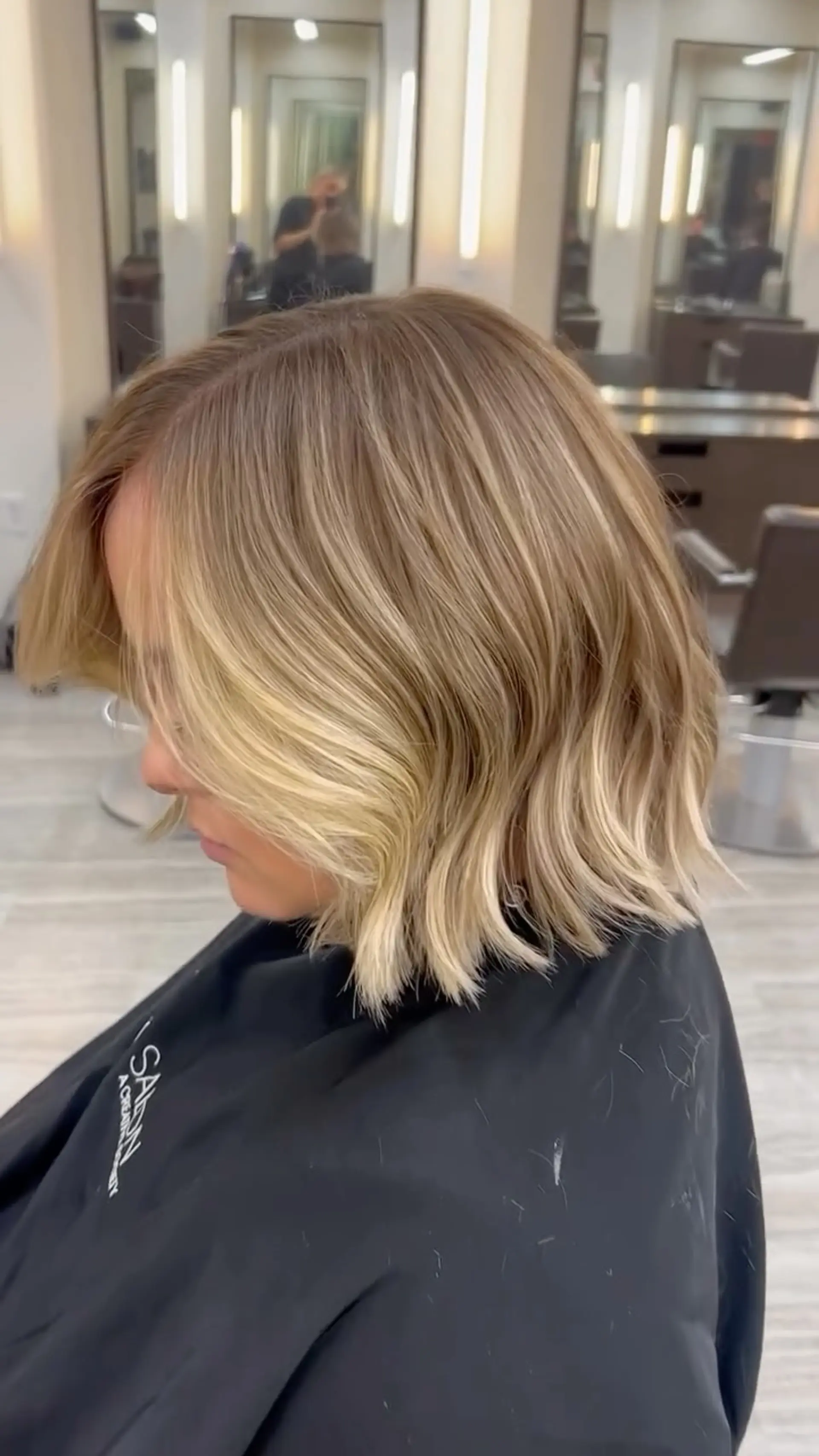A textured chin-to-collarbone bob styled with soft, undone waves and dimensional blonde highlighting. 1