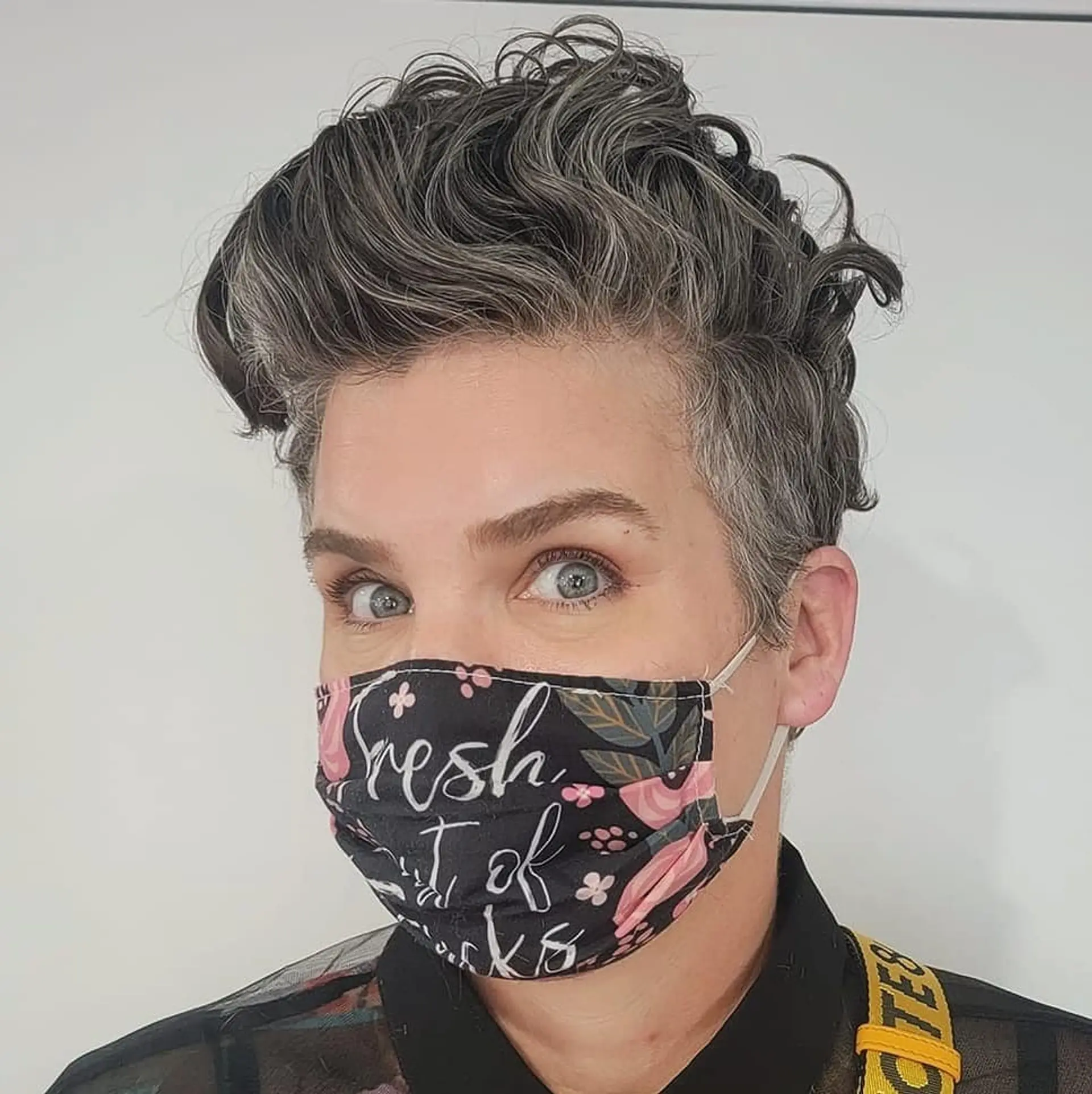 A voluminous curly quiff with an undercut, primarily in shades of gray and black, combining elements of taper and fade with a fuller, curly top. 2