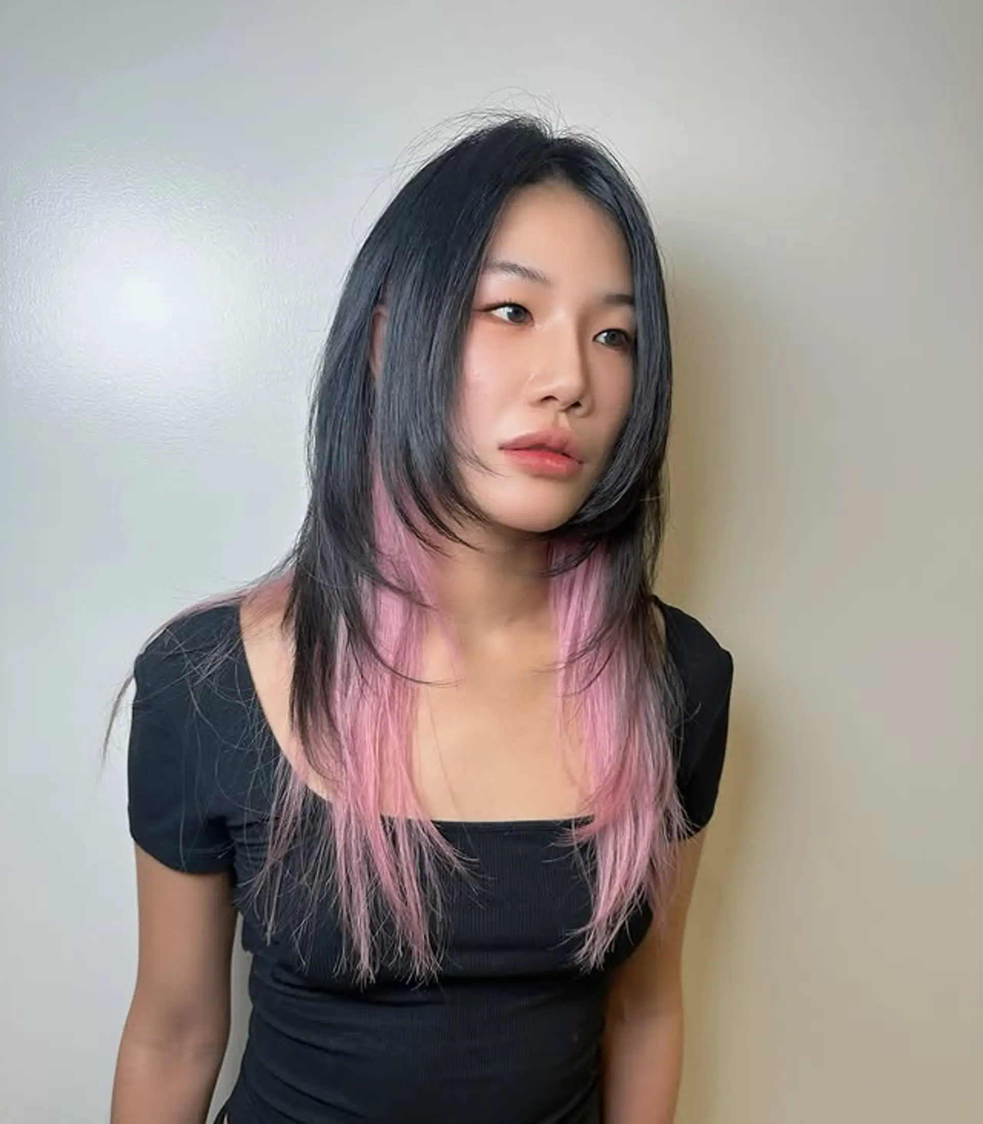 A medium-length layered hairstyle with pink money piece. 1
