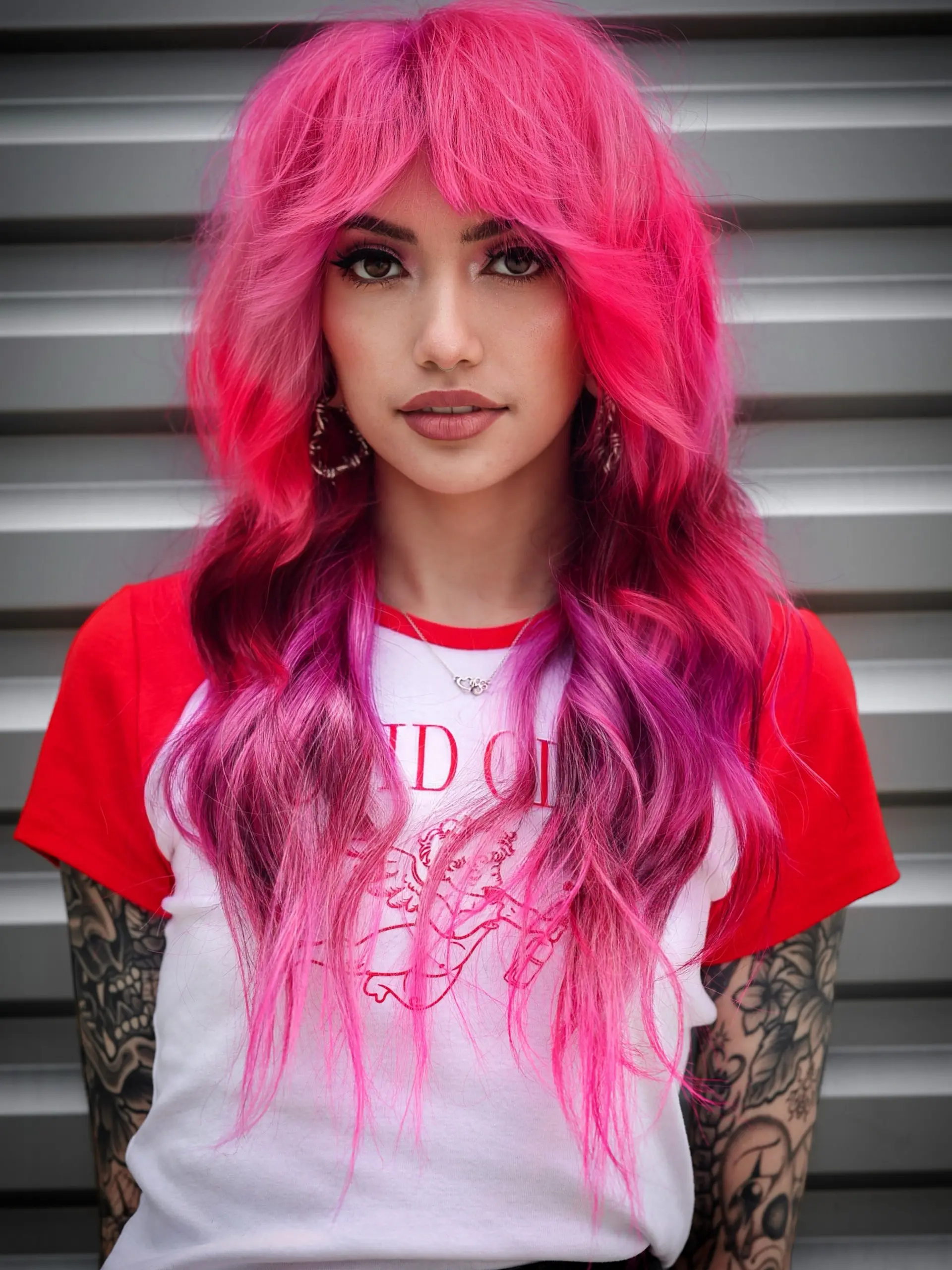 A voluminous hot pink and magenta shag haircut featuring textured curtain bangs and soft, face-framing waves. 1