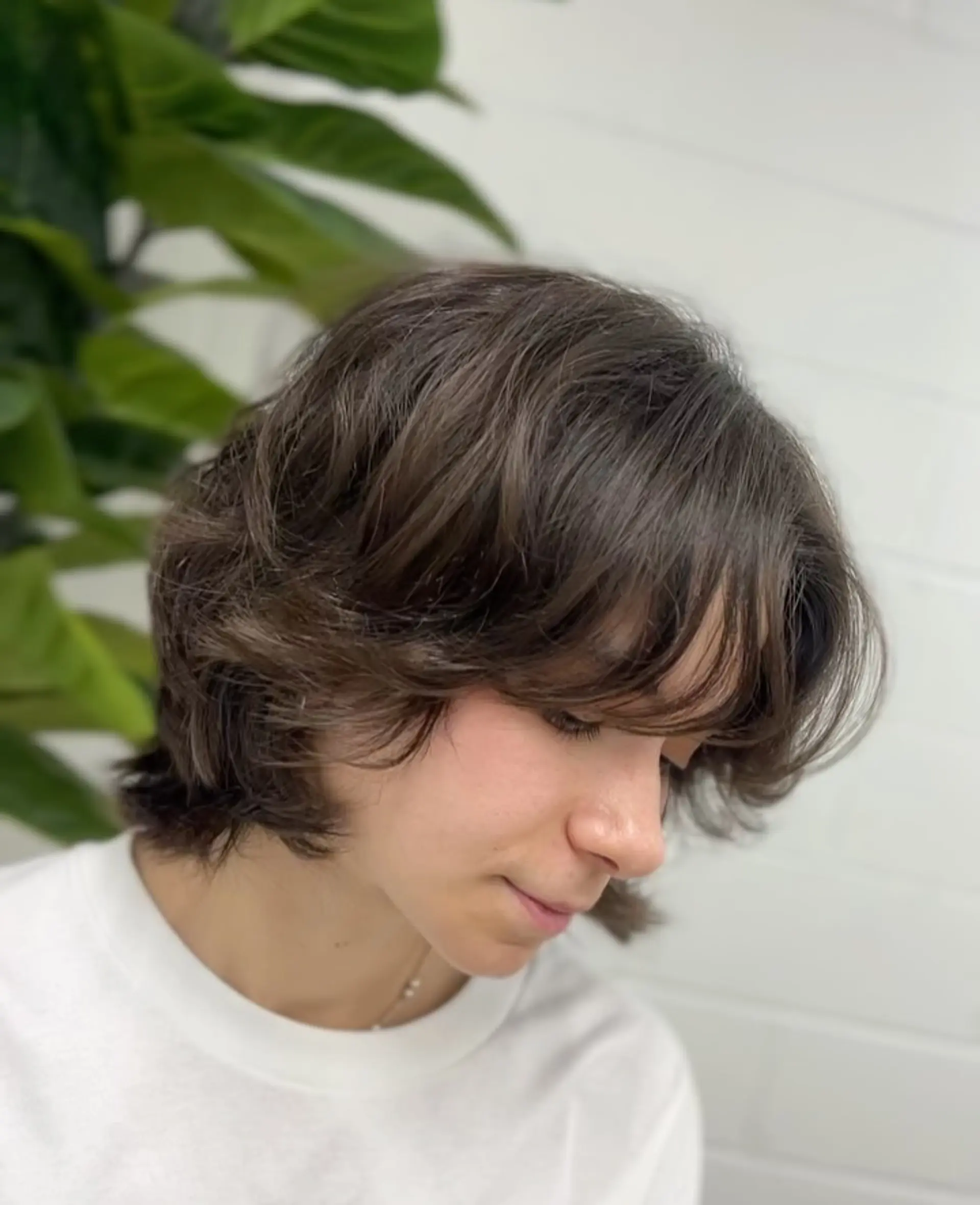 A textured short layered bob featuring soft curtain bangs and airy, face-framing movement. 1