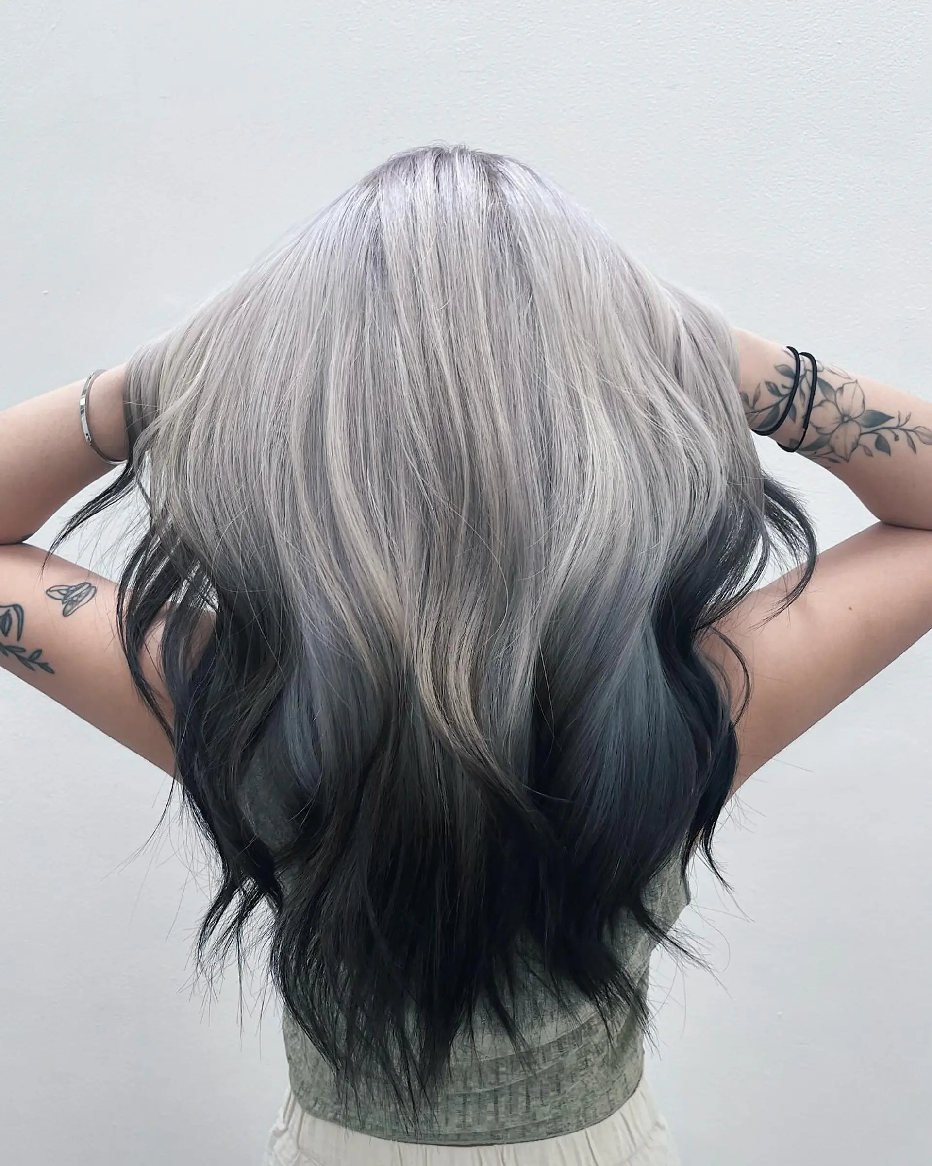 Long wavy hair with a platinum silver to dark black ombre, showcasing layered waves and a striking two-tone effect. 1