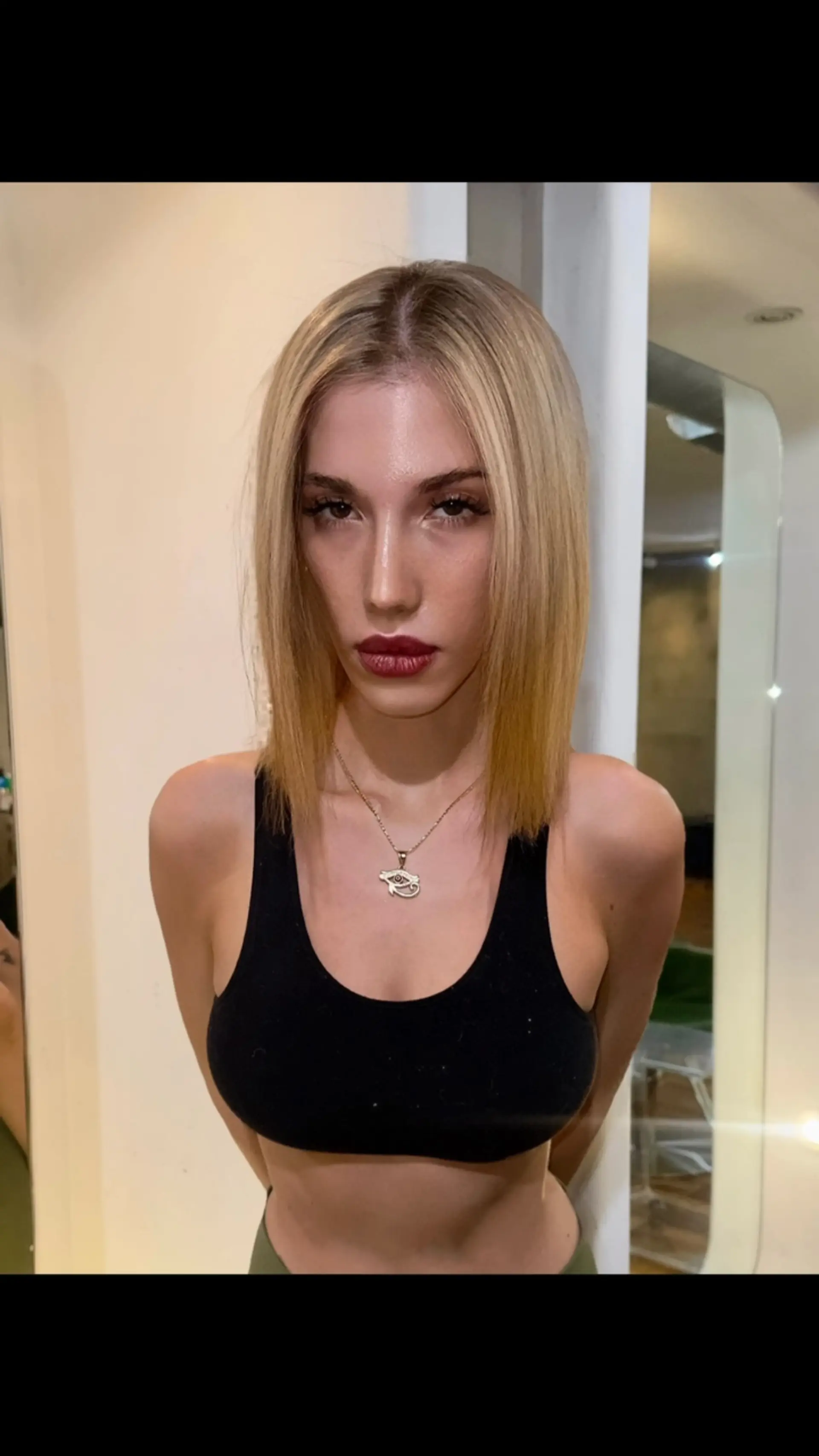 A sleek, collarbone-length blunt lob styled straight with a center part in a warm honey blonde tone. 1