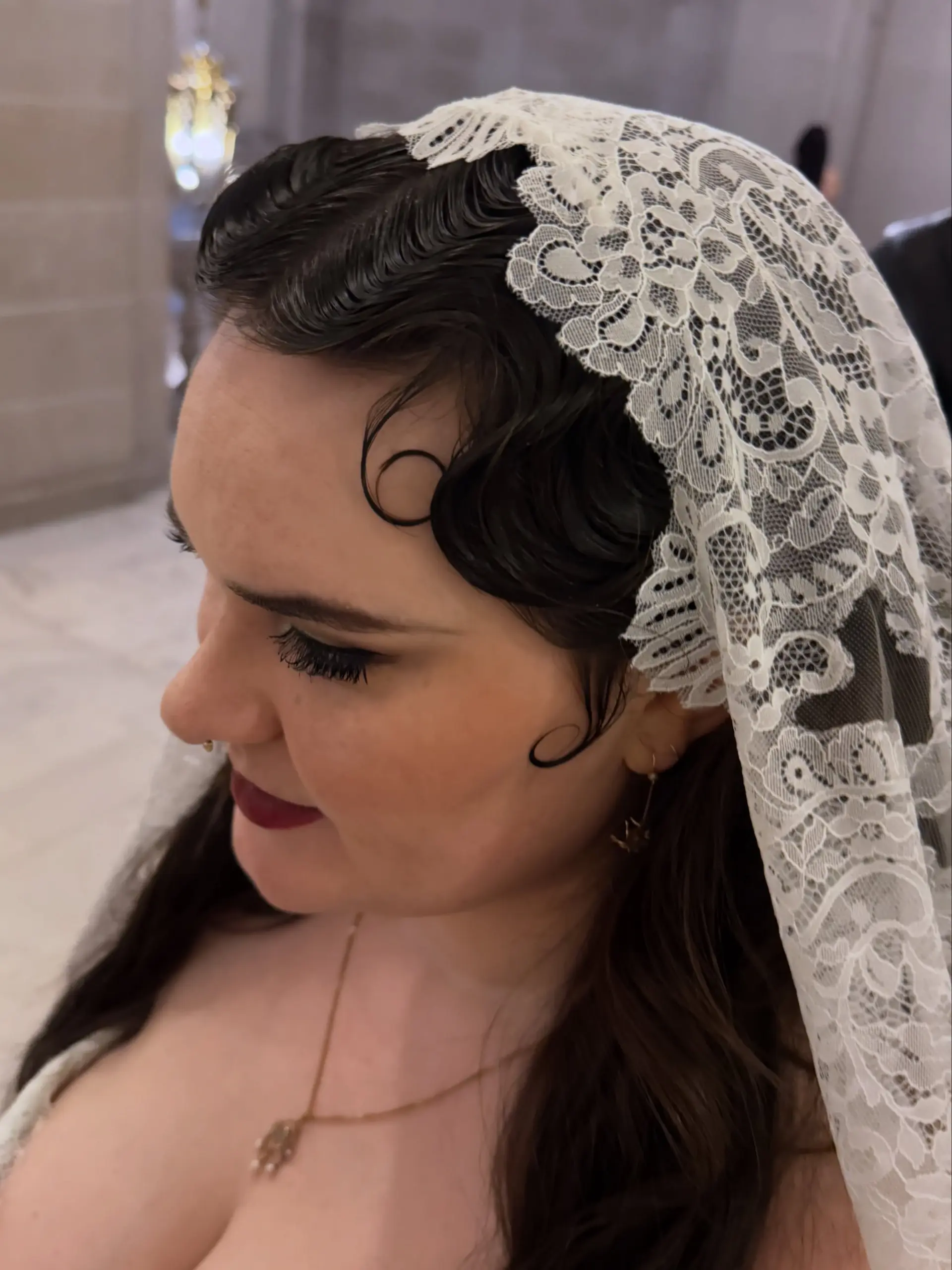 Vintage-inspired finger waves and delicate pin curls styled neatly along the hairline with a lace bridal veil. 1