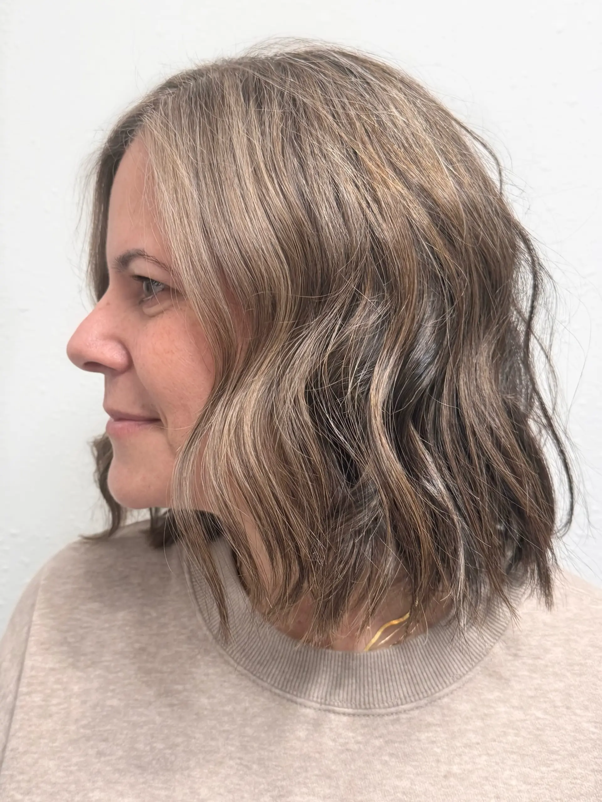 A textured shoulder-length wavy bob featuring seamless gray blending and fine cool-toned babylights. 1