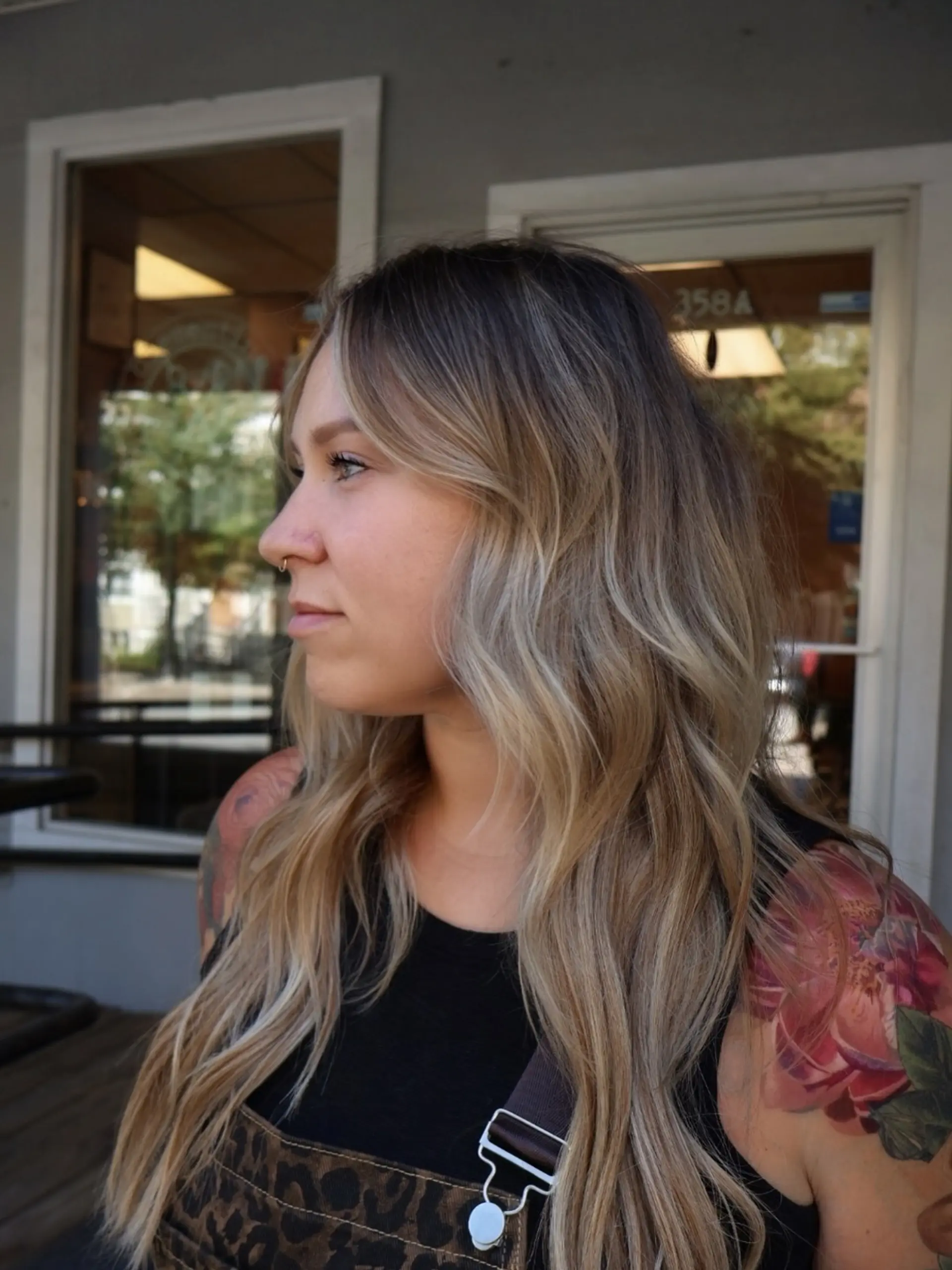Long lived-in dimensional blonde hair styled in soft, natural waves with light face-framing strands. 1