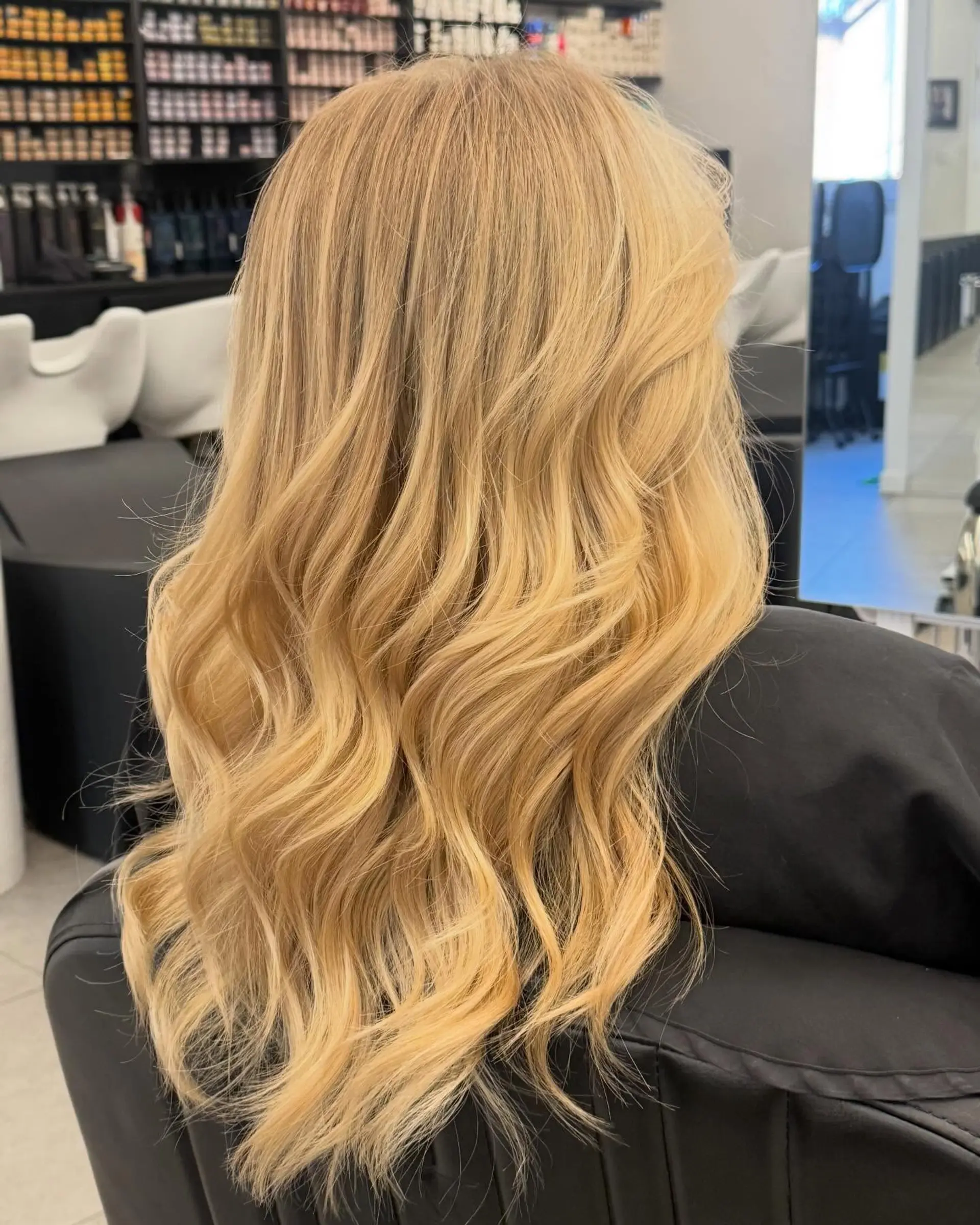 Long golden blonde hair styled with soft, voluminous beach waves. 1