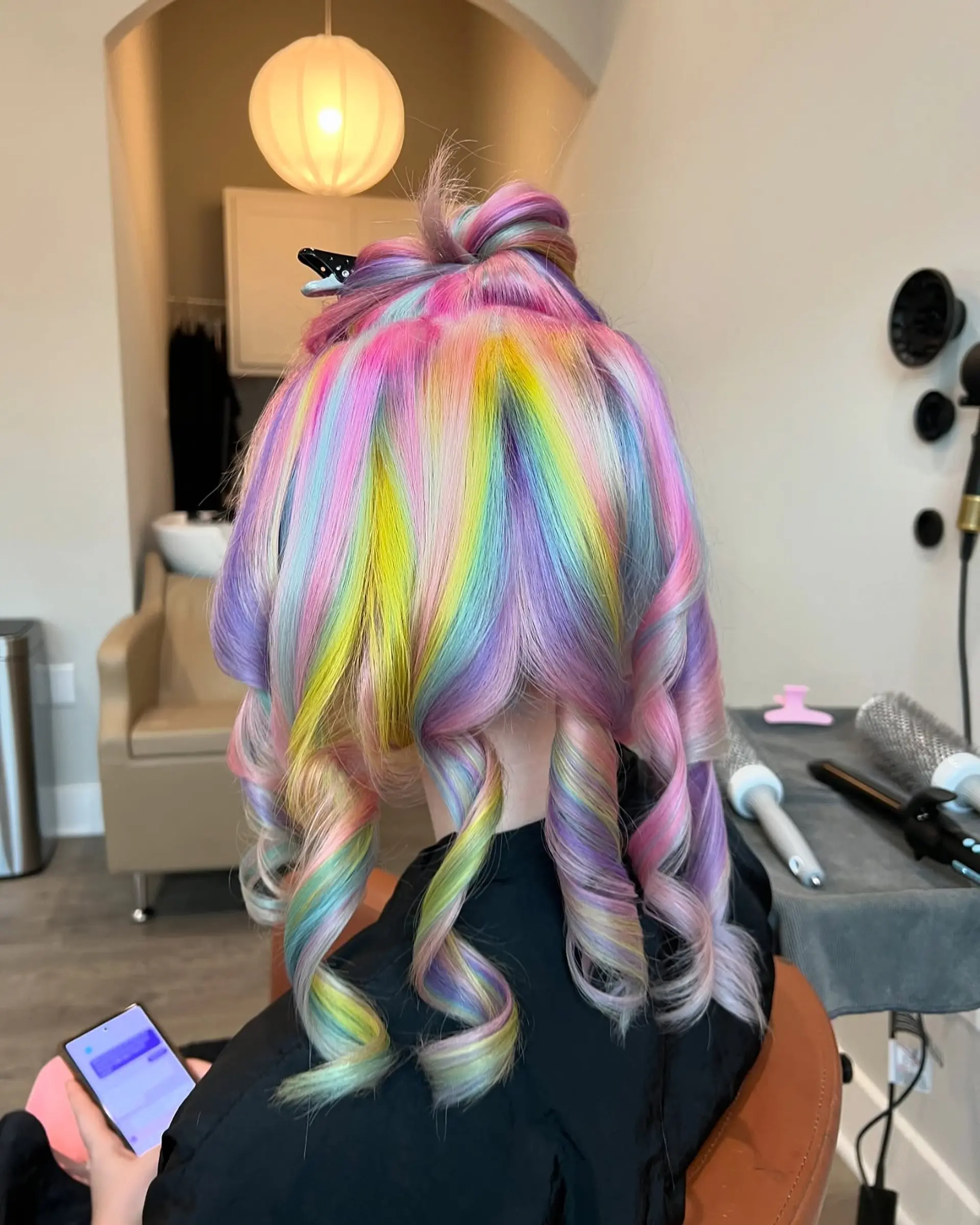 This eye-catching hairstyle showcases medium-length wavy hair adorned with a full spectrum of pastel rainbow colors, blended seamlessly for a magical, vivid, and whimsical unicorn effect. 2