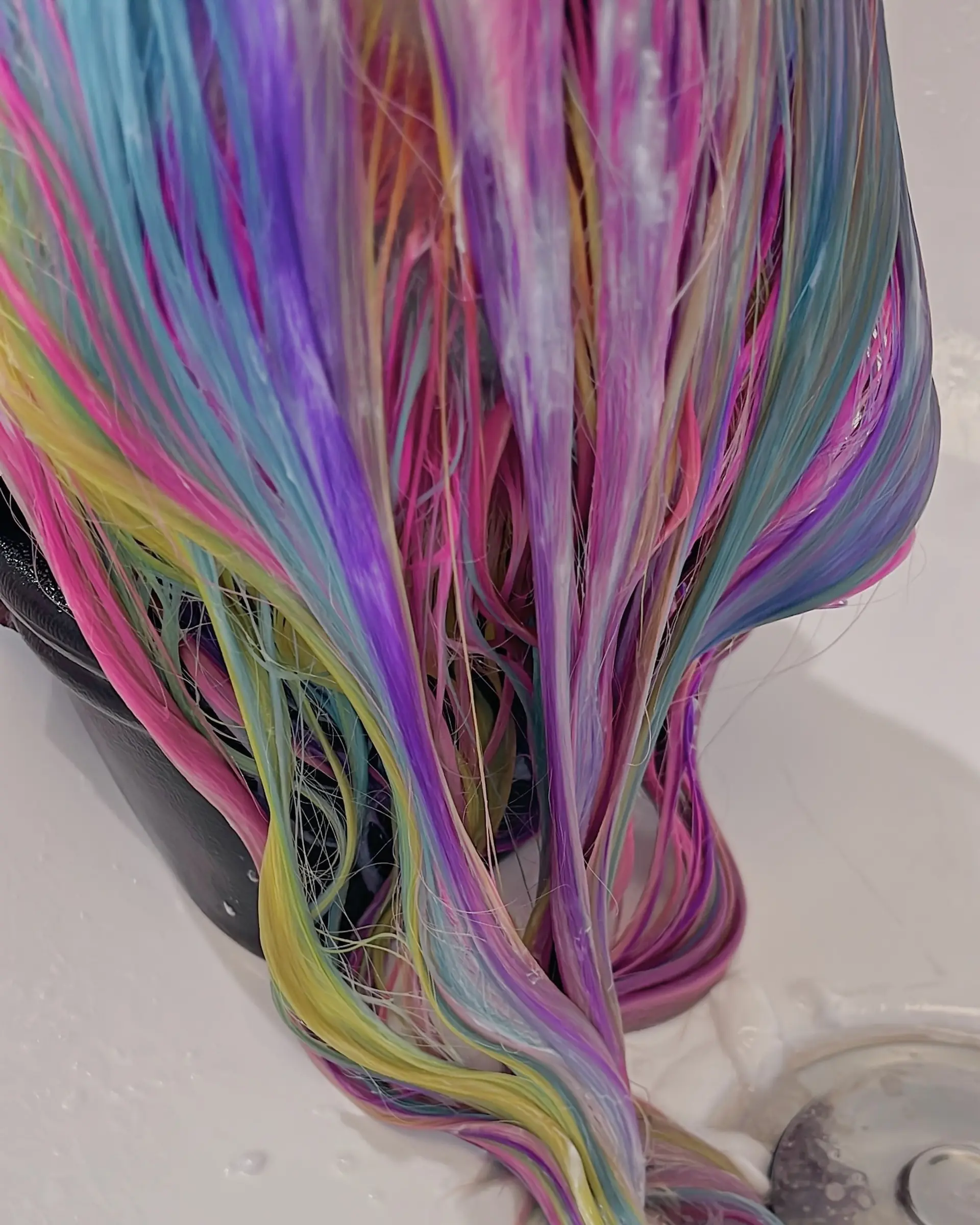 This eye-catching hairstyle showcases medium-length wavy hair adorned with a full spectrum of pastel rainbow colors, blended seamlessly for a magical, vivid, and whimsical unicorn effect. 5