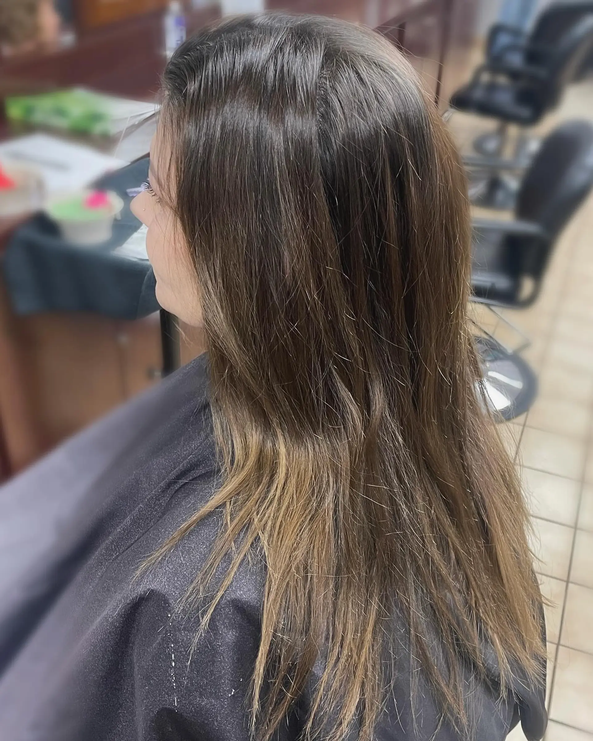 Long straight brunette hair enhanced with fine, warm caramel highlights concentrated through the mid-lengths and ends. 1