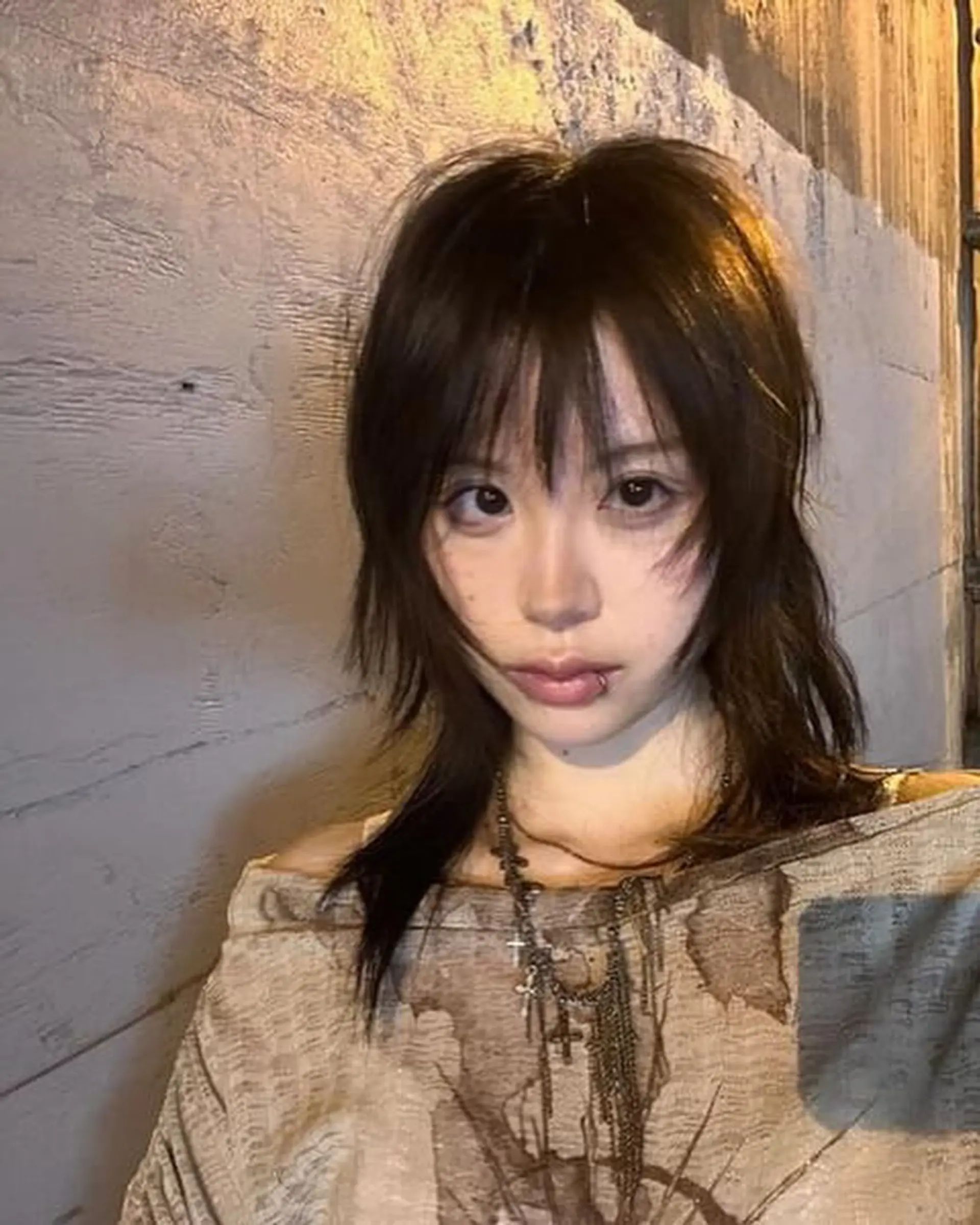 An edgy, medium-length shag cut with dark brown, straight hair. It features layered textures, choppy fringe, and face-framing layers, creating a modern, stylish aesthetic. 2